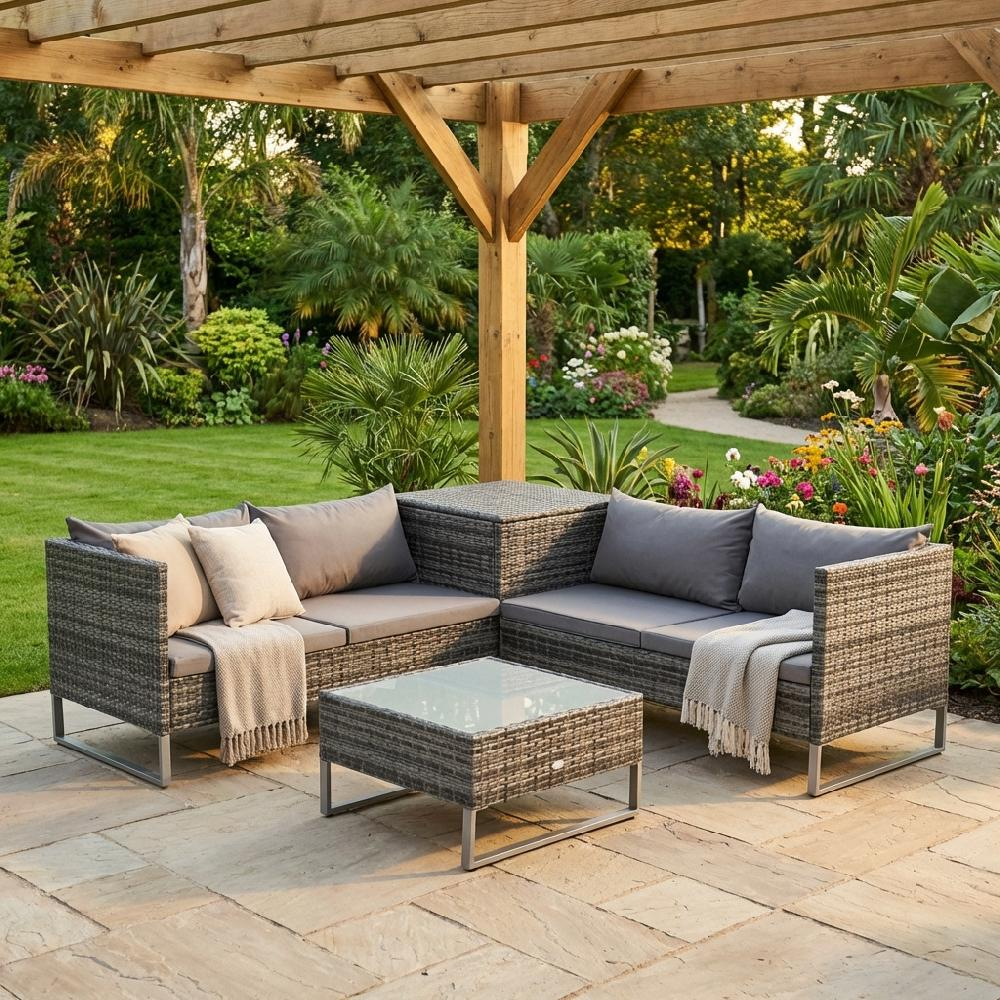 Divano in rattan con tavolino in vetro su patio sotto pergola in legno, giardino rigoglioso.