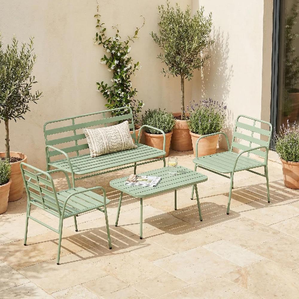 Un set di mobili da giardino verdi con panchina, due sedie e un tavolo su un patio.