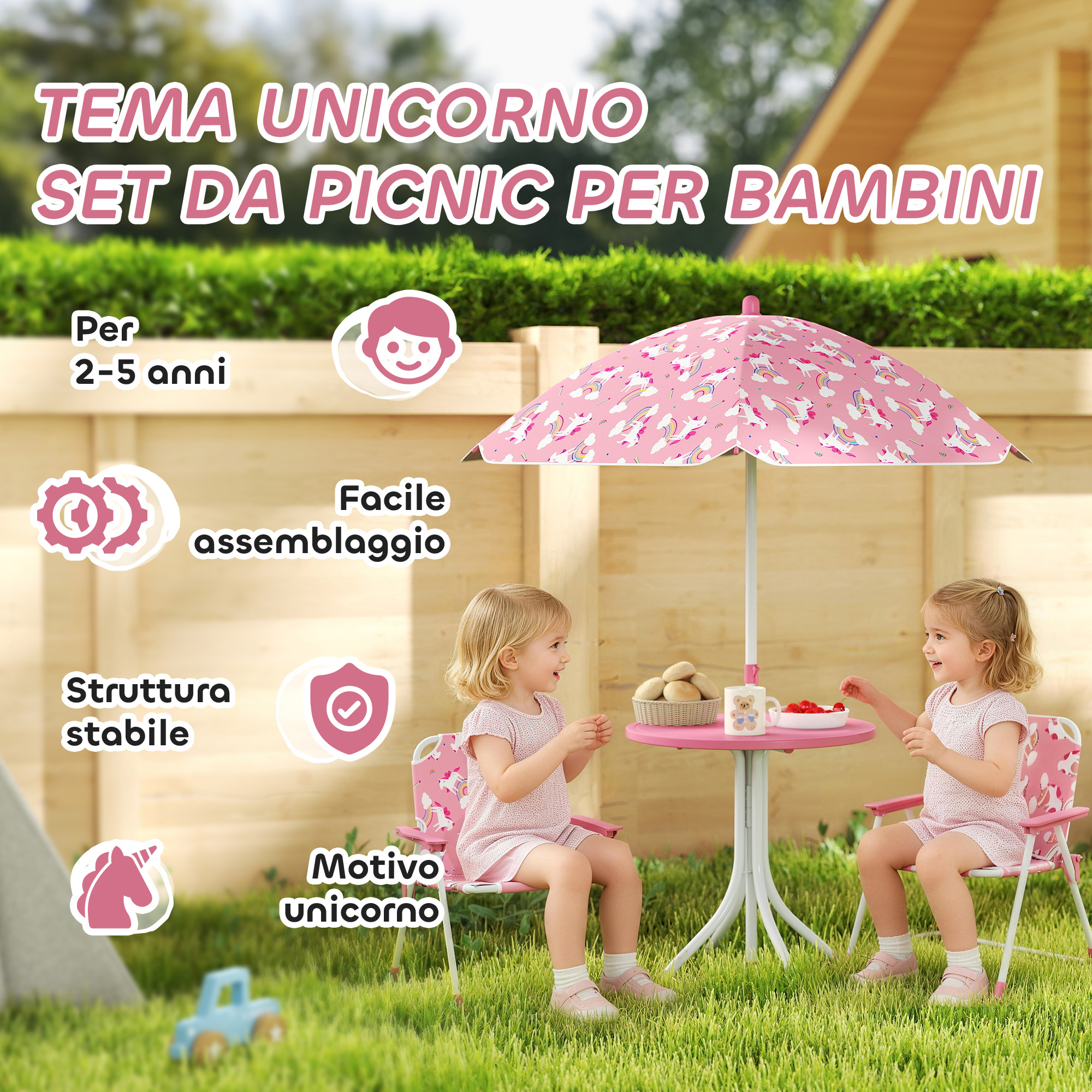 Due bambine sedute a un tavolino da picnic rosa sotto un ombrellone con unicorni.