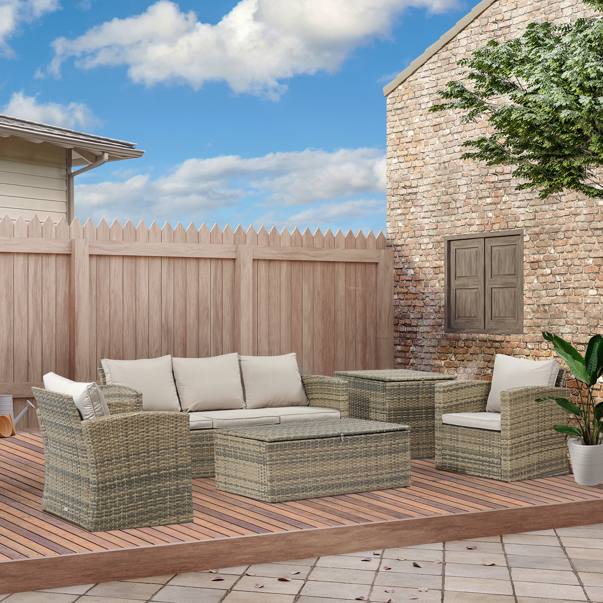 Set di mobili da giardino in vimini su terrazza in legno, con muro di mattoni e recinzione.