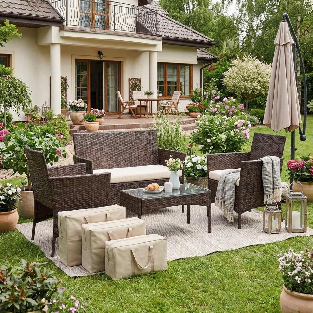 Un set di mobili da giardino in rattan con divano, poltrone, tavolino, ombrellone e borse portaoggetti.