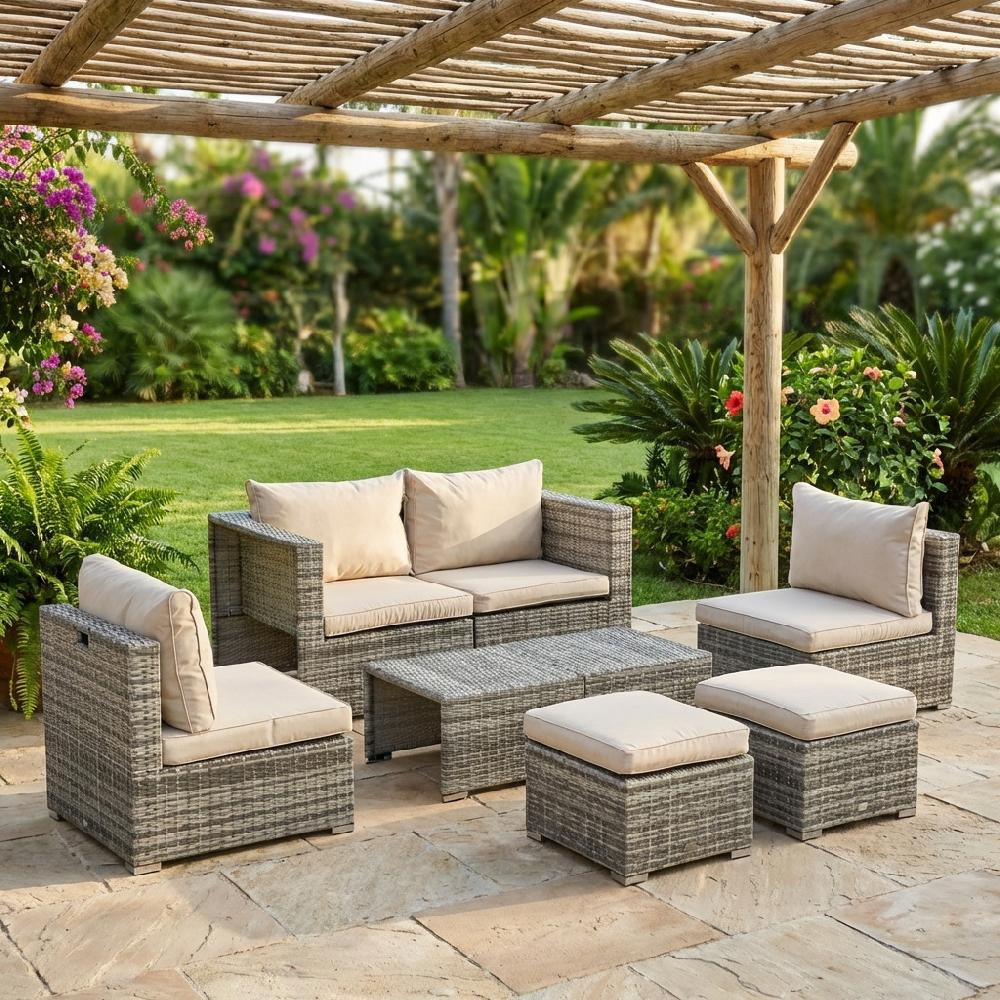 Set di mobili da giardino in rattan con cuscini color crema sotto un pergolato in legno.