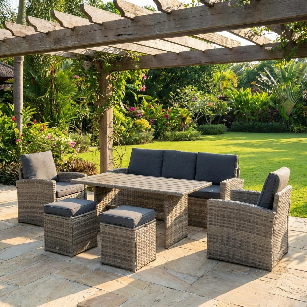 Set di mobili da giardino in vimini sotto un pergolato in legno con vegetazione lussureggiante.