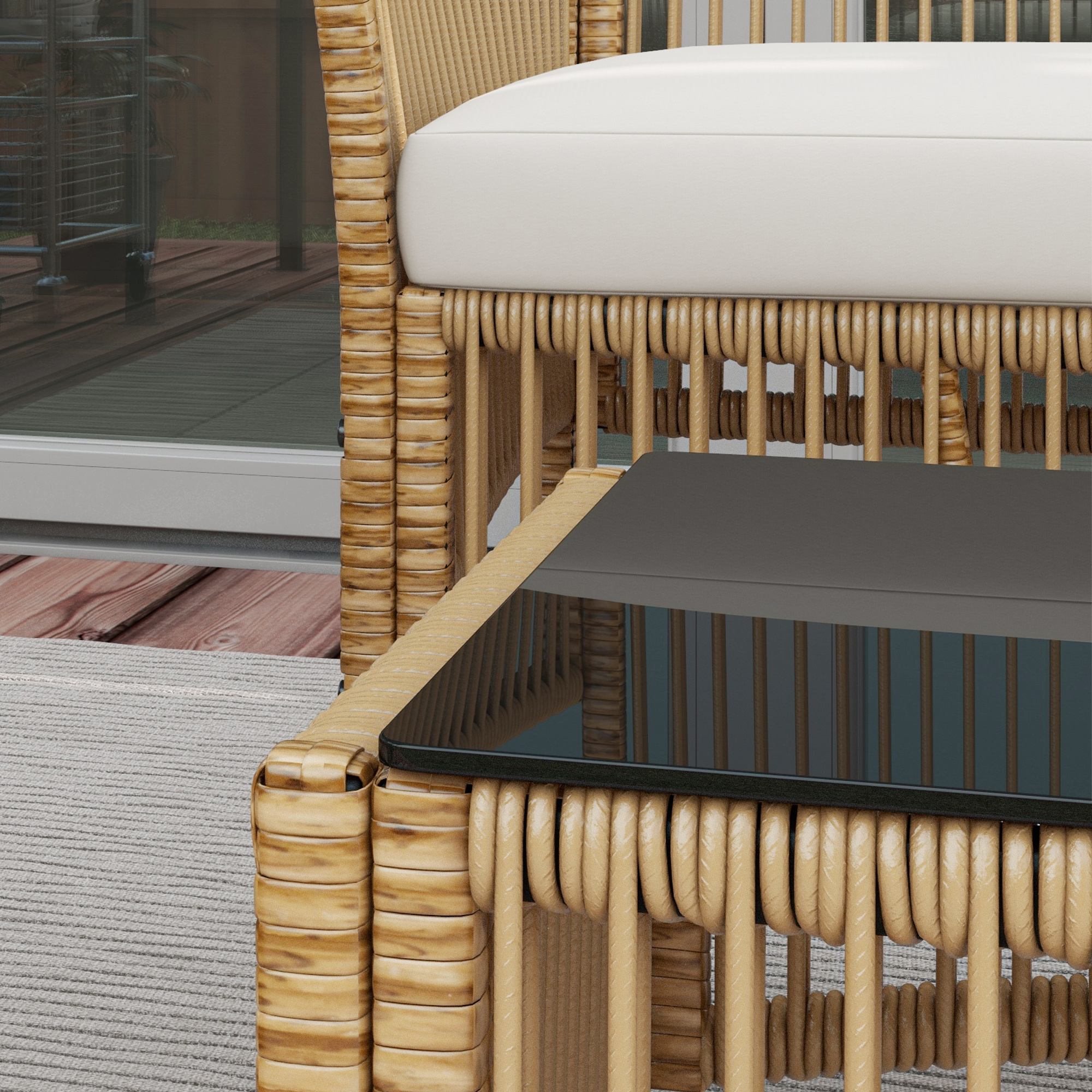 Un tavolino in rattan con piano in vetro nero accanto a una poltrona in rattan con cuscino bianco.