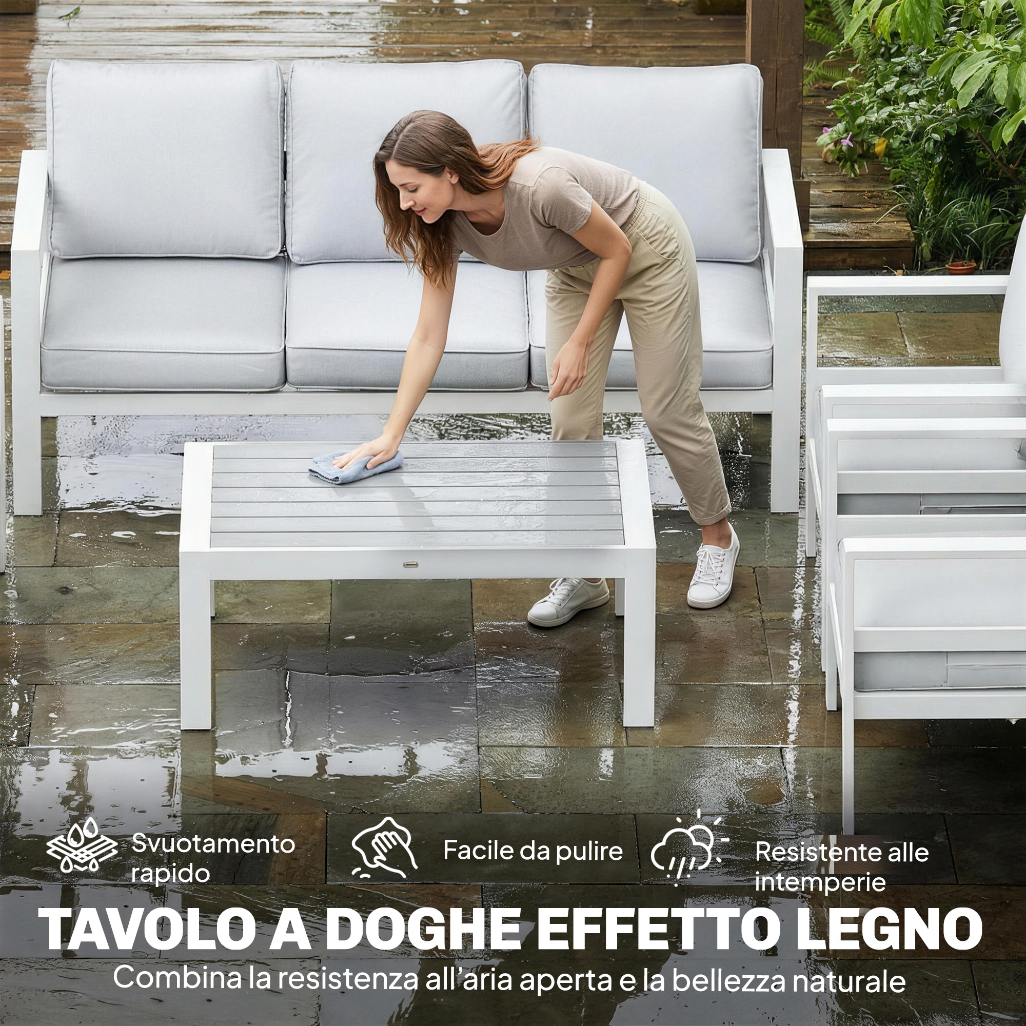 Donna pulisce tavolo. Mobili da esterno con cuscini grigi su patio.