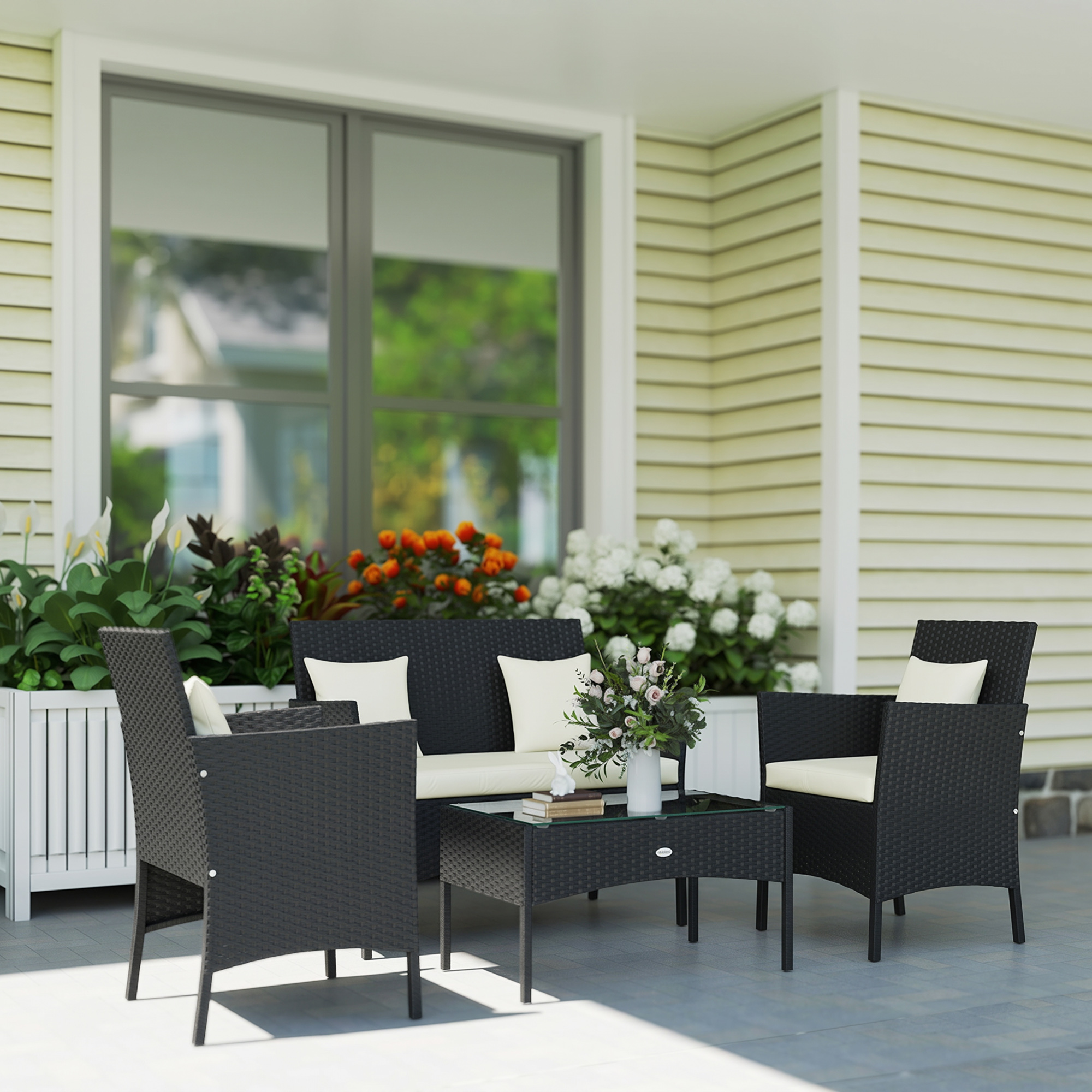 Set di mobili in rattan con cuscini su un portico.