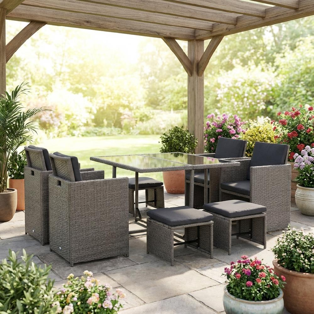 Un set da pranzo da giardino con sei sedie e sgabelli in rattan sotto una pergola in legno.