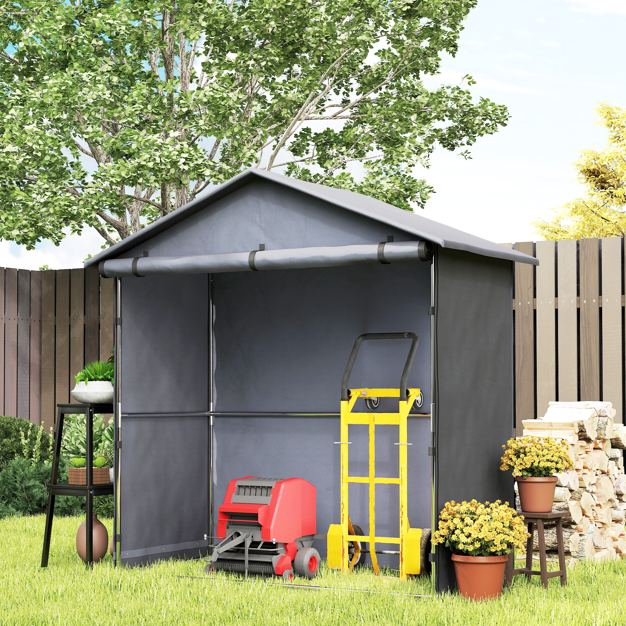 Un capanno porta attrezzi grigio con tosaerba, carrello, legna e piante in giardino.