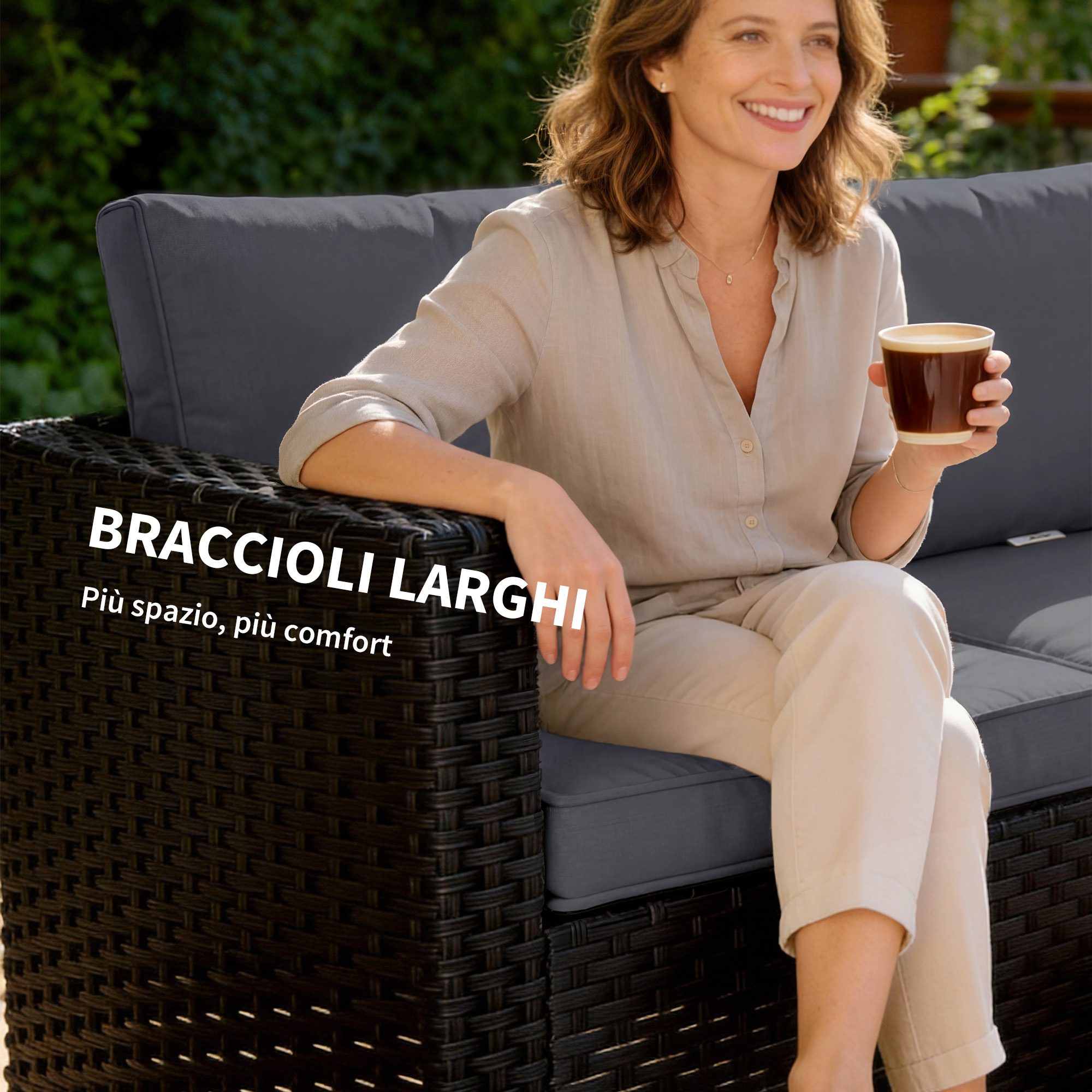 Donna seduta su divano in rattan scuro con cuscino grigio, tiene tazza caffè.