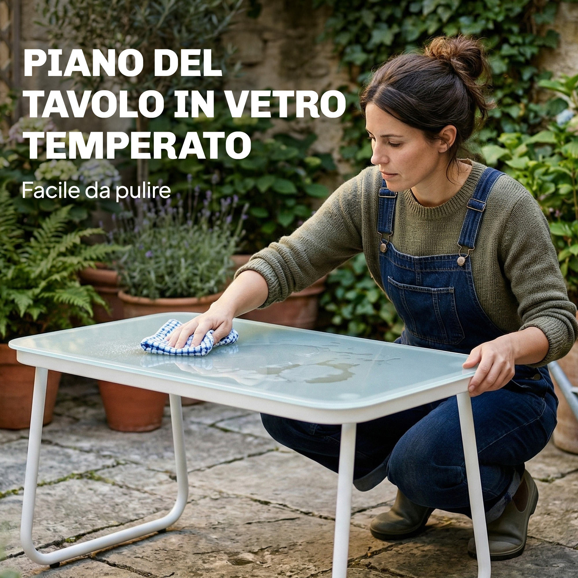 Donna pulisce tavolo in vetro all'aperto con panno a quadretti. Piante sullo sfondo.