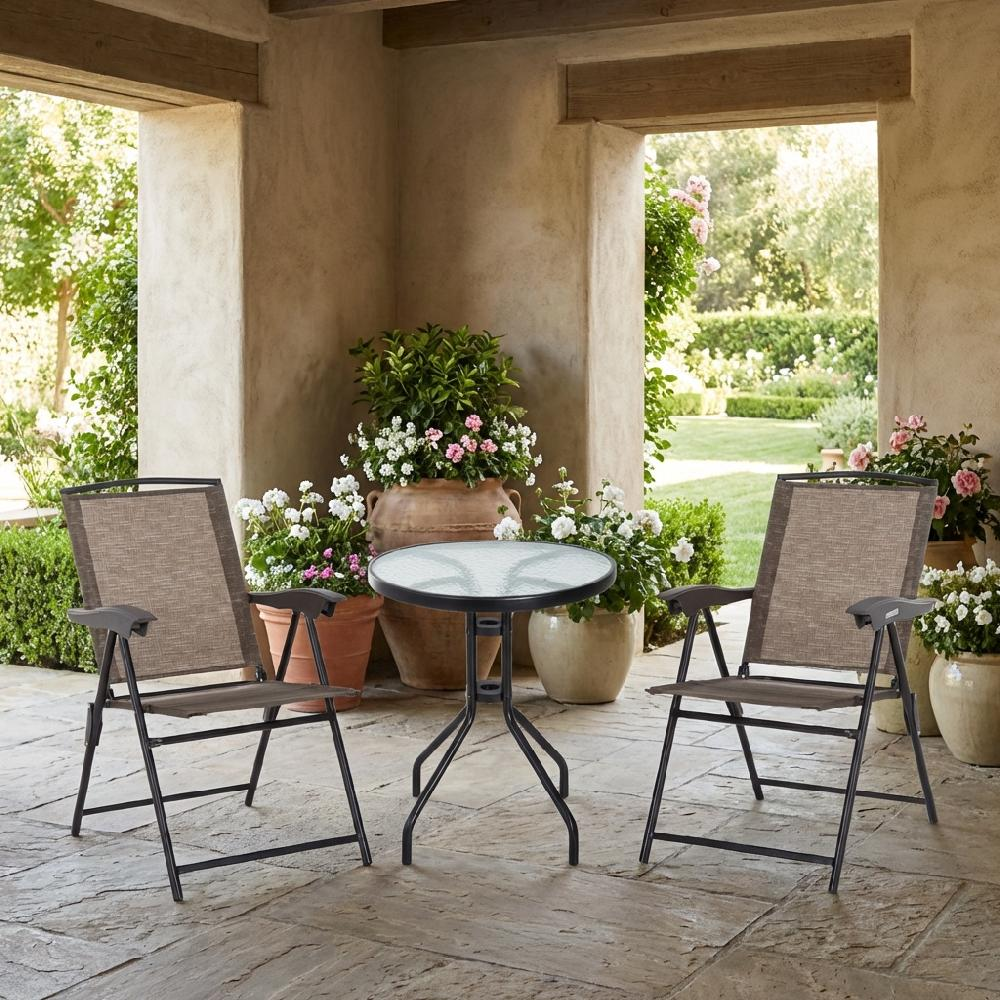 Due sedie da esterno marroni e un tavolino rotondo in vetro su un patio in pietra.