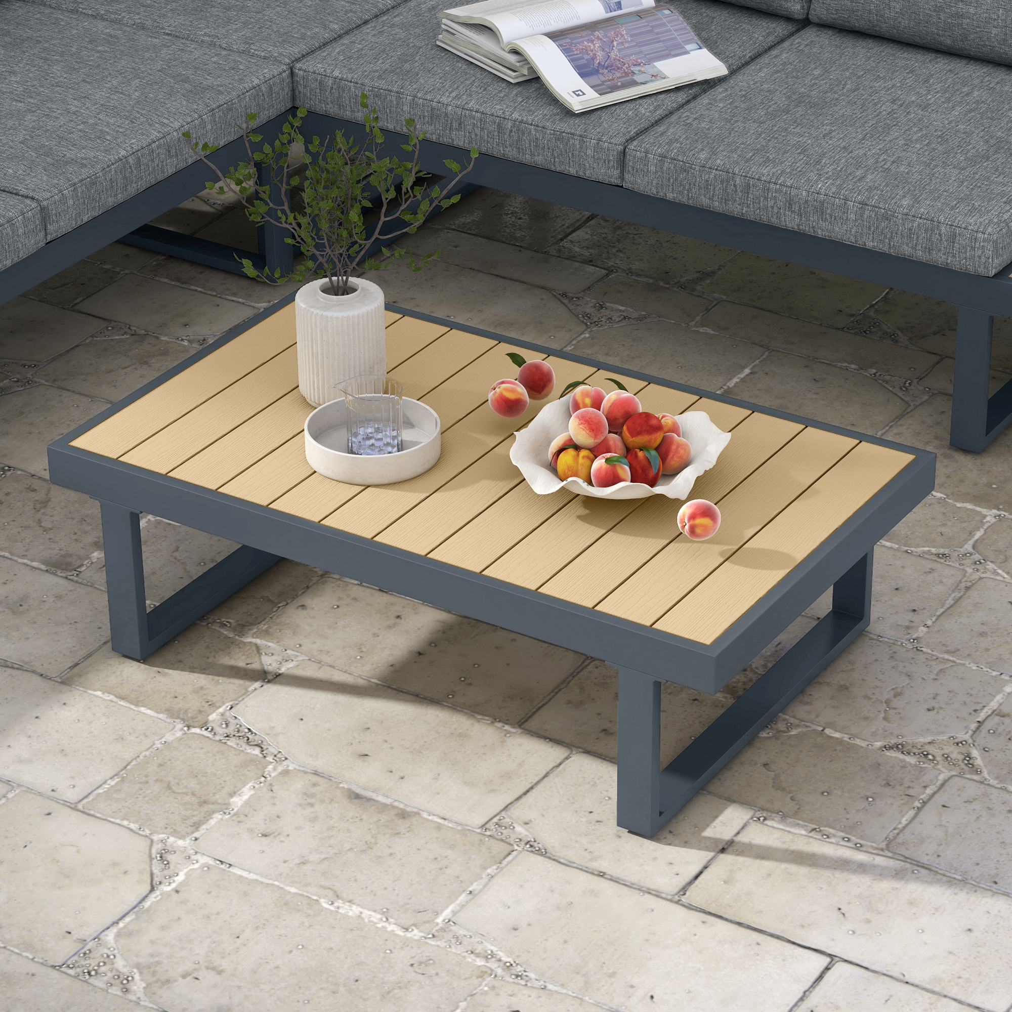 Un tavolino da caffè con piano in laminato di legno e struttura grigio scuro, con frutta e vaso.
