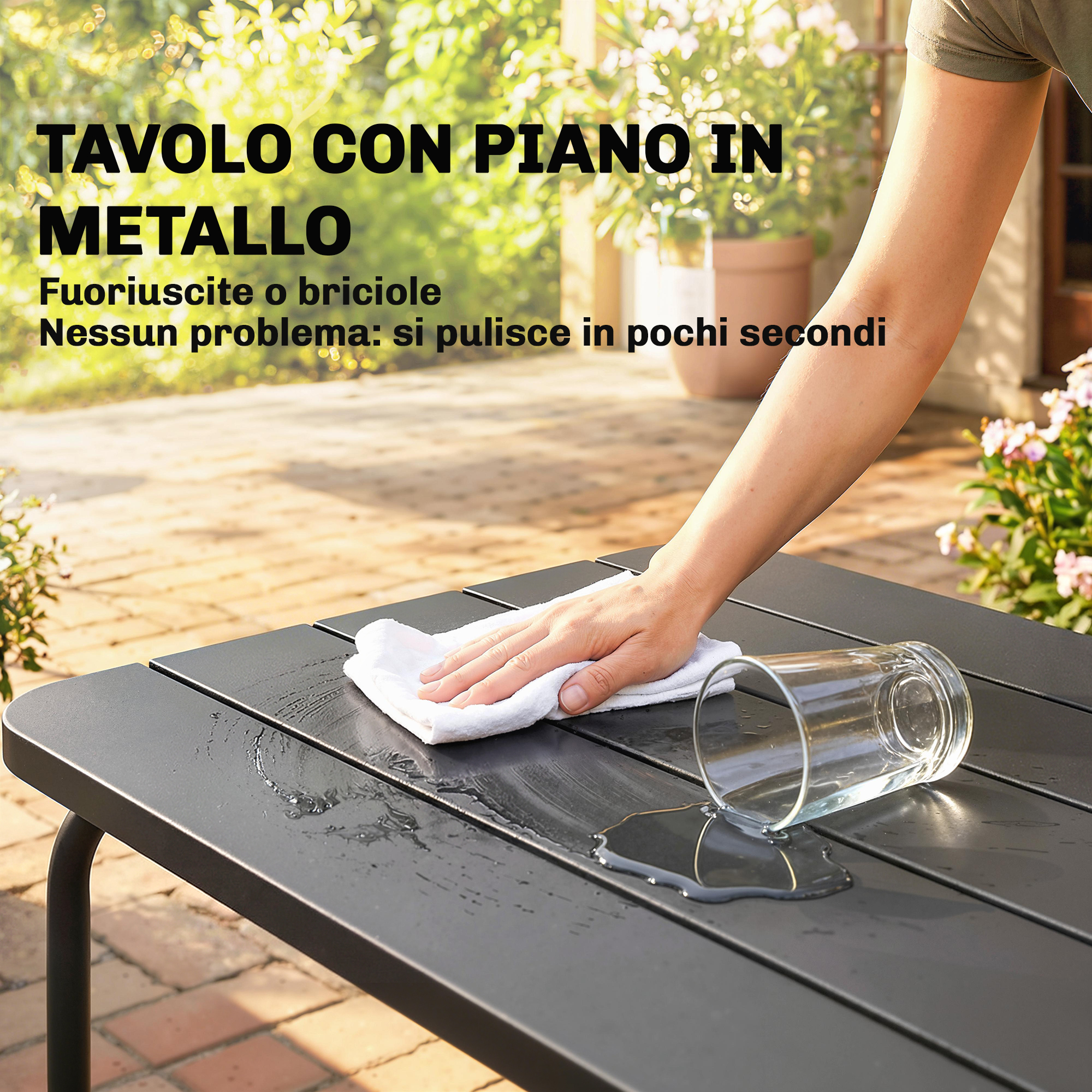 Una mano pulisce un tavolo in metallo nero con un panno bianco, con acqua versata.