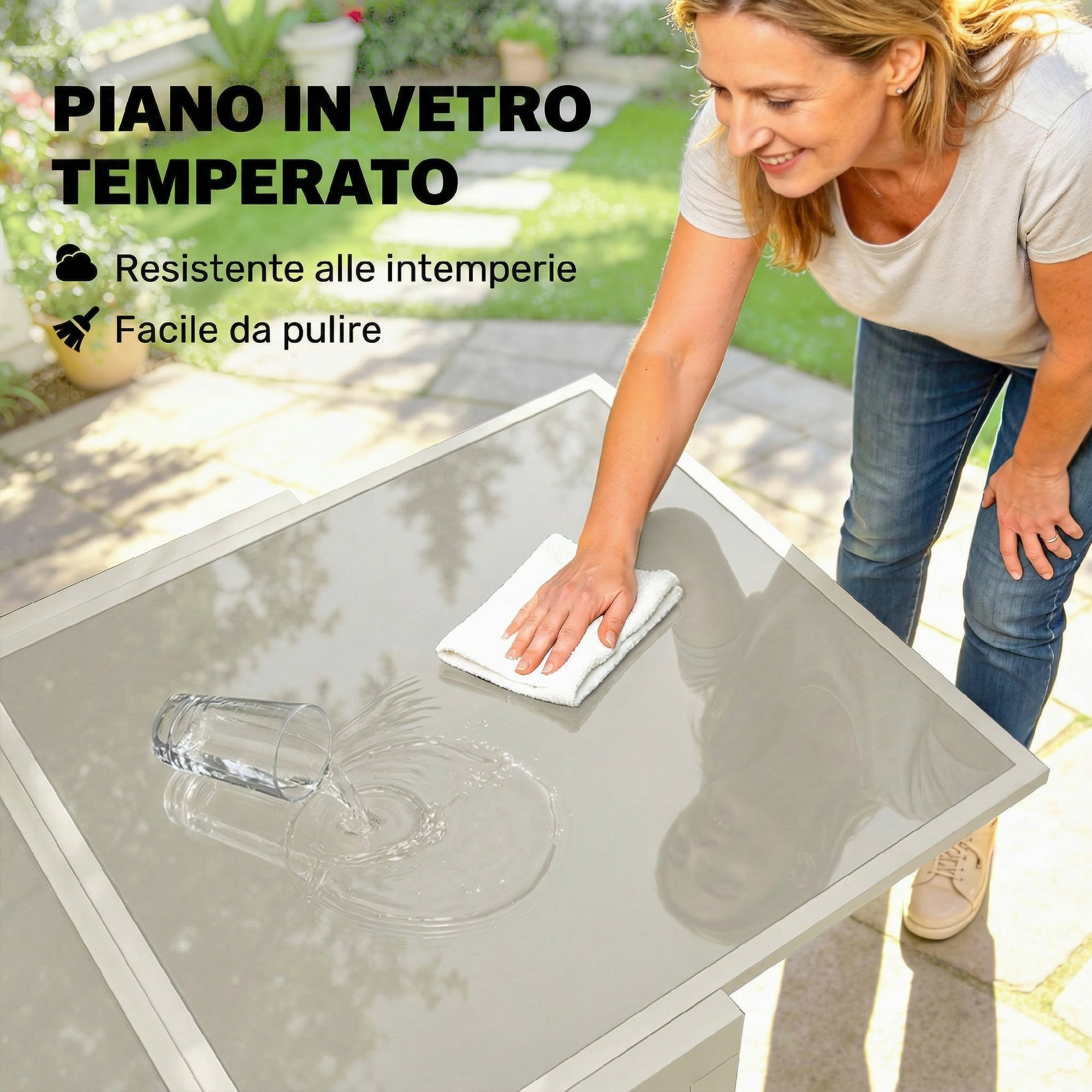 Donna pulisce tavolo con panno; bicchiere d'acqua rovesciato.