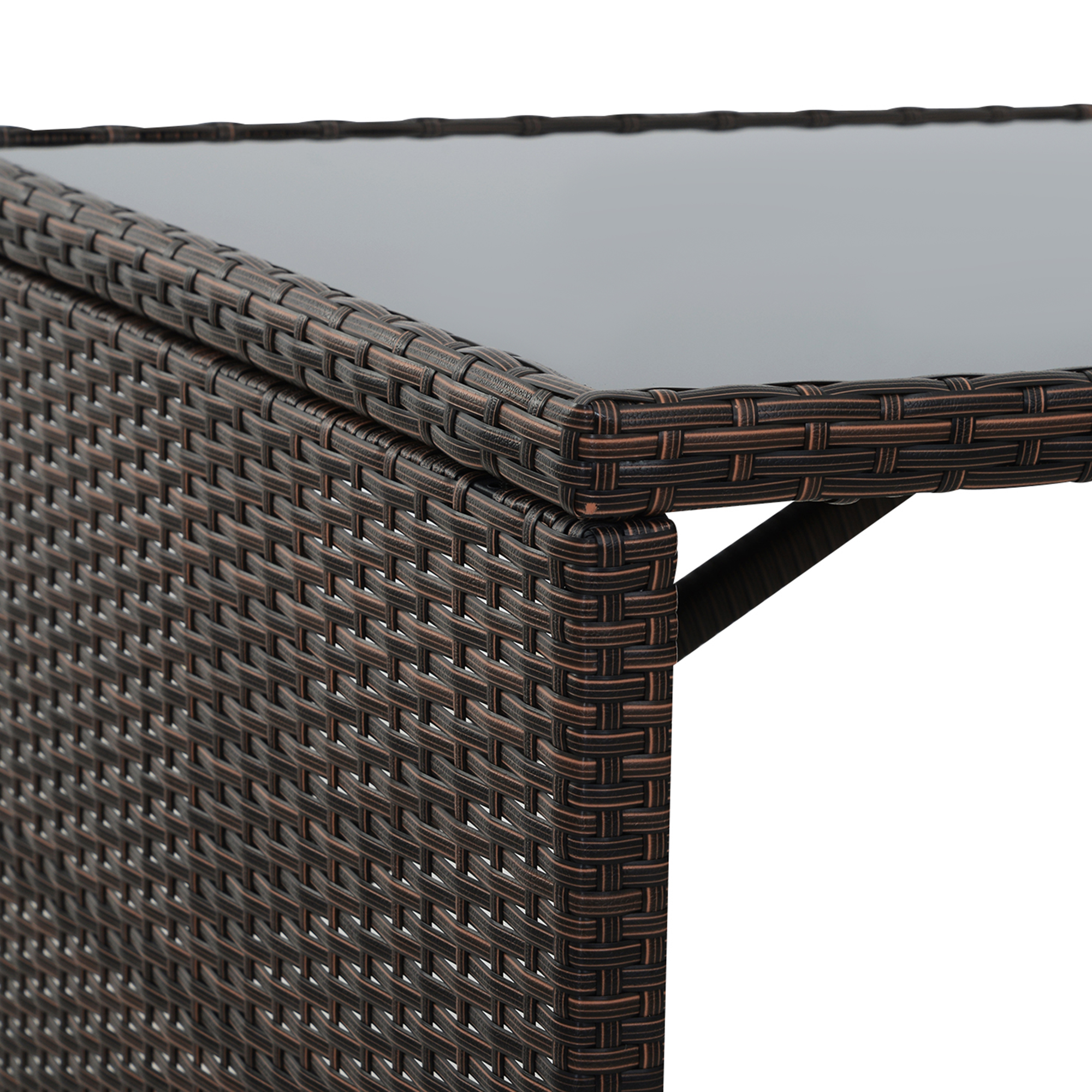Tavolo in rattan marrone con piano in vetro, primo piano del lato.