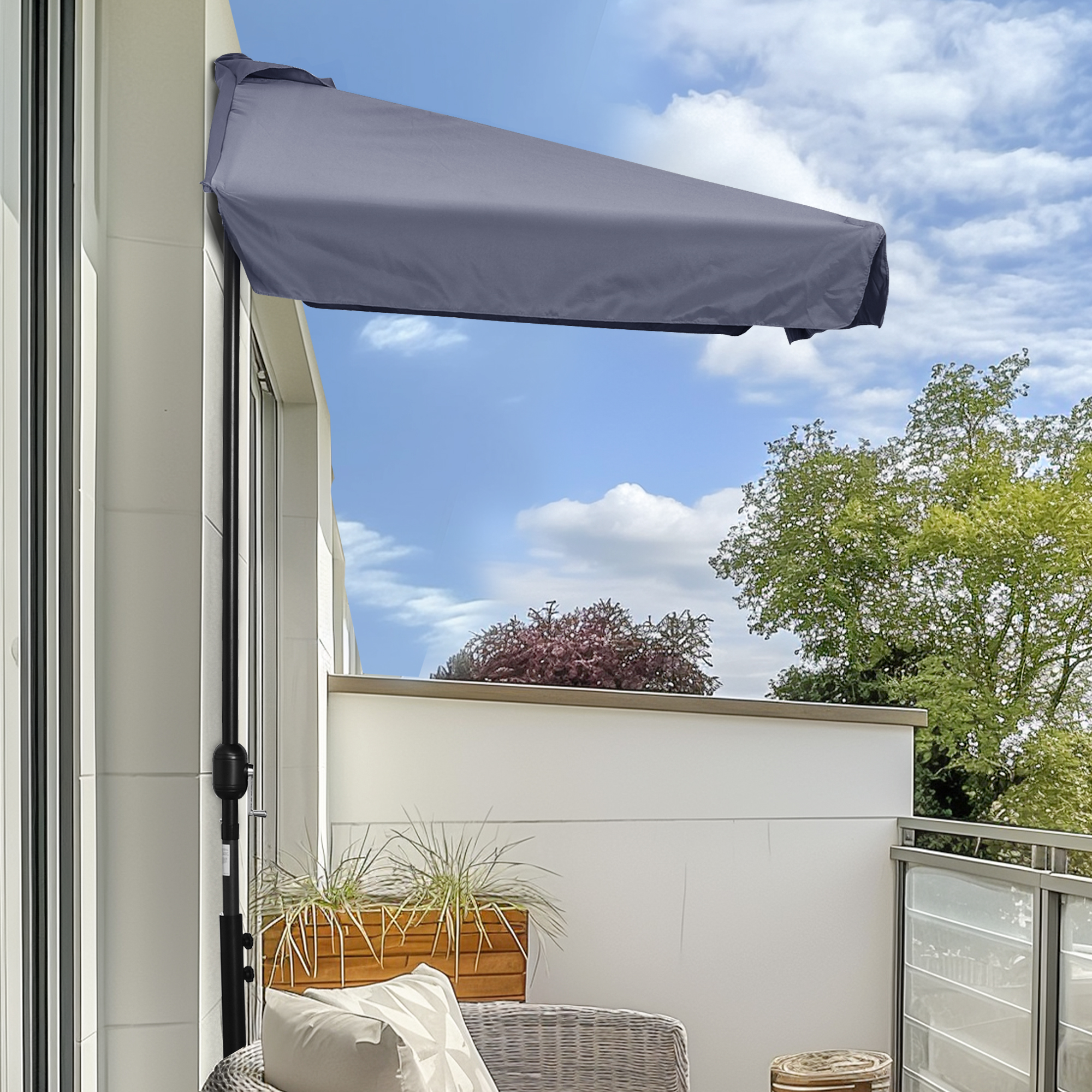 Una tenda da sole grigia è fissata a un muro bianco di casa.