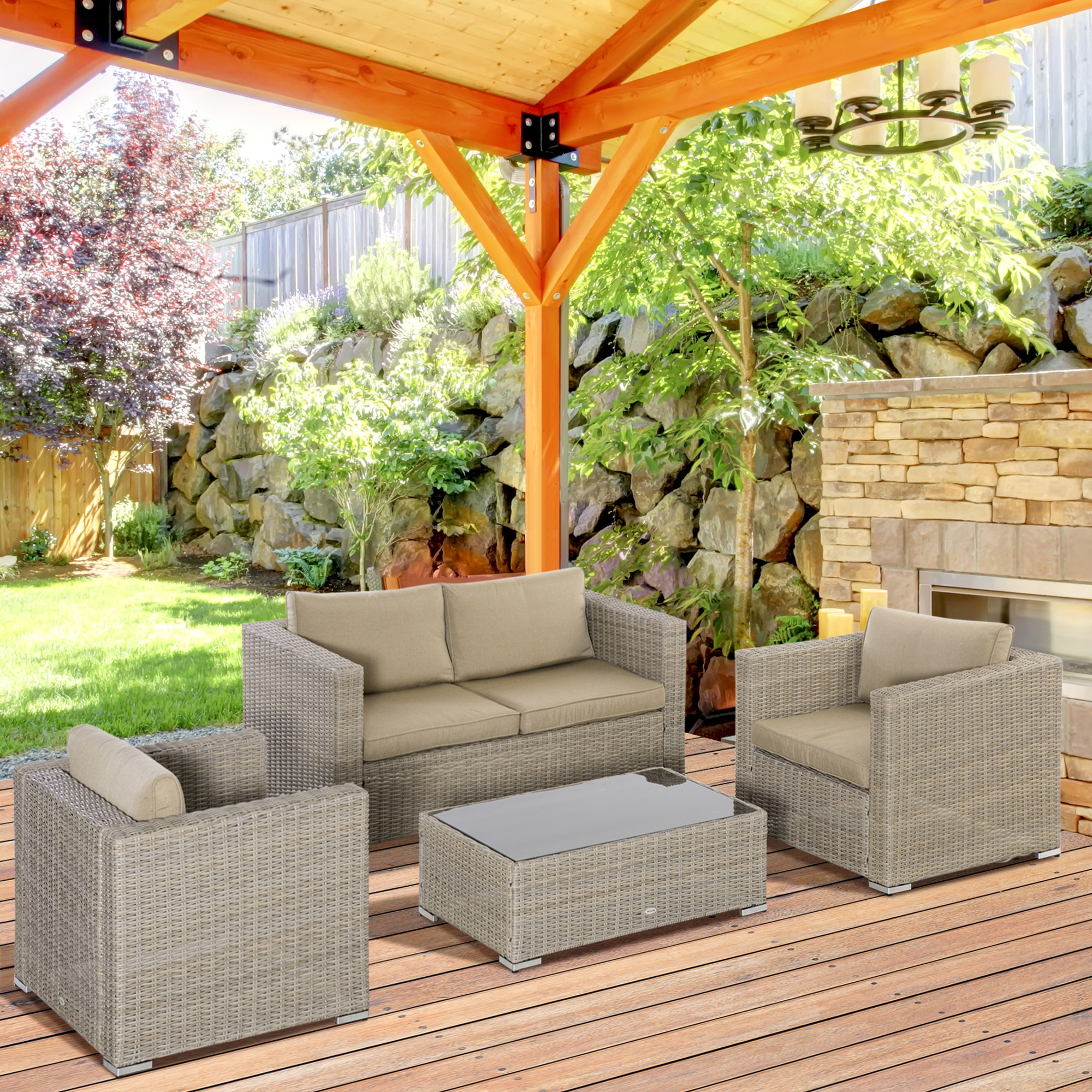 Divano da giardino in rattan color cuoio con tavolino su deck in legno sotto pergola.