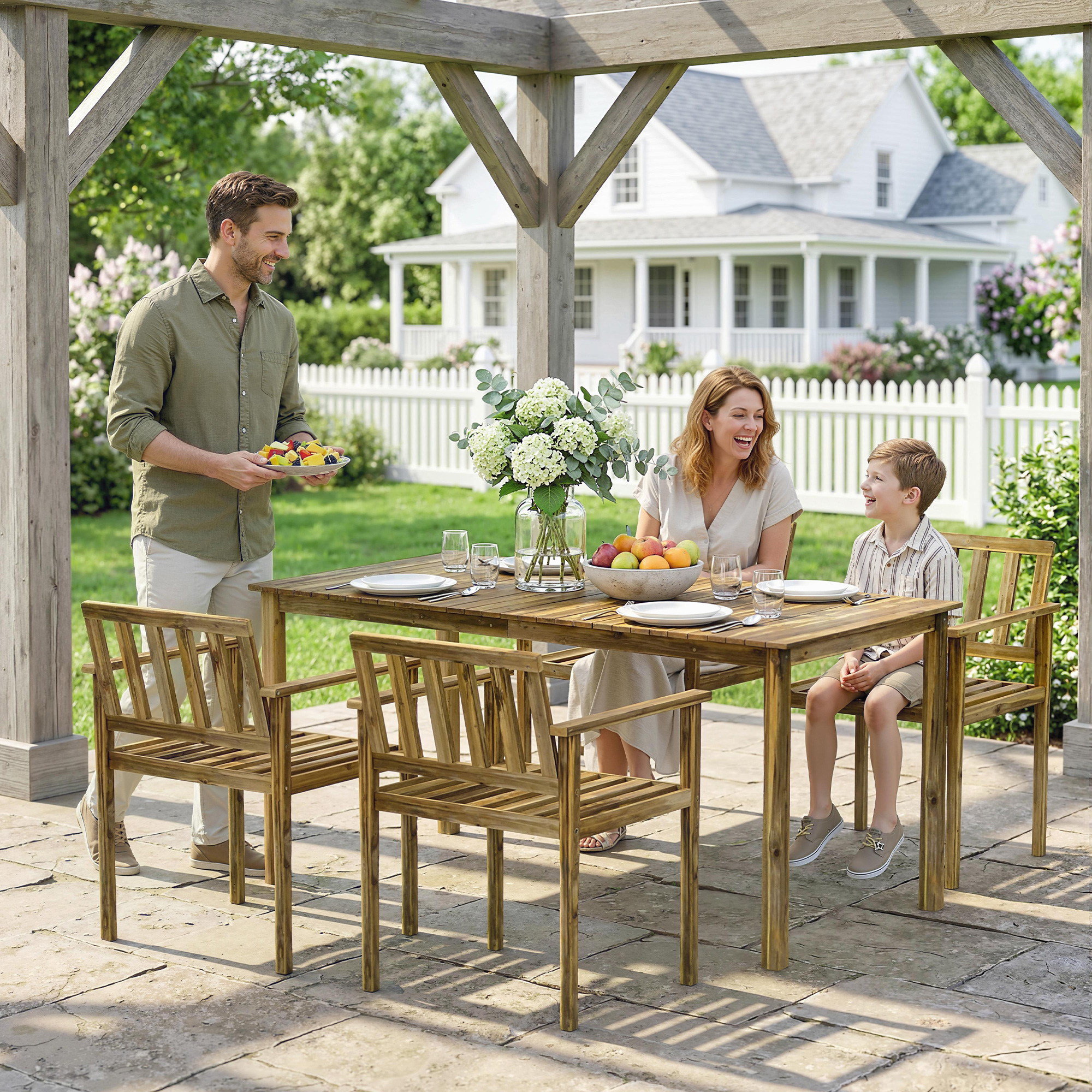 Famiglia gode di un picnic in giardino sotto un pergolato con una casa sullo sfondo.