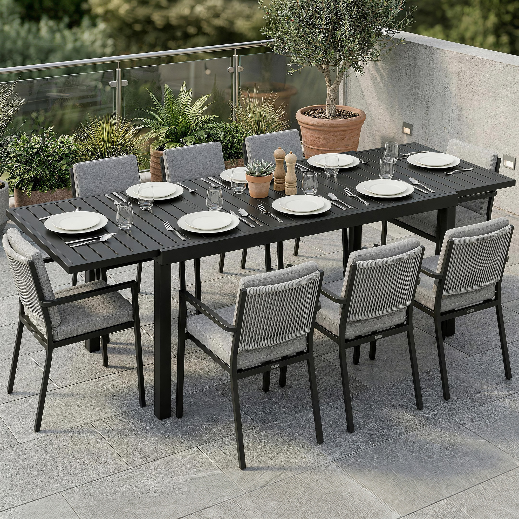 Un tavolo da pranzo nero per otto persone con cuscini grigi su un patio piastrellato.