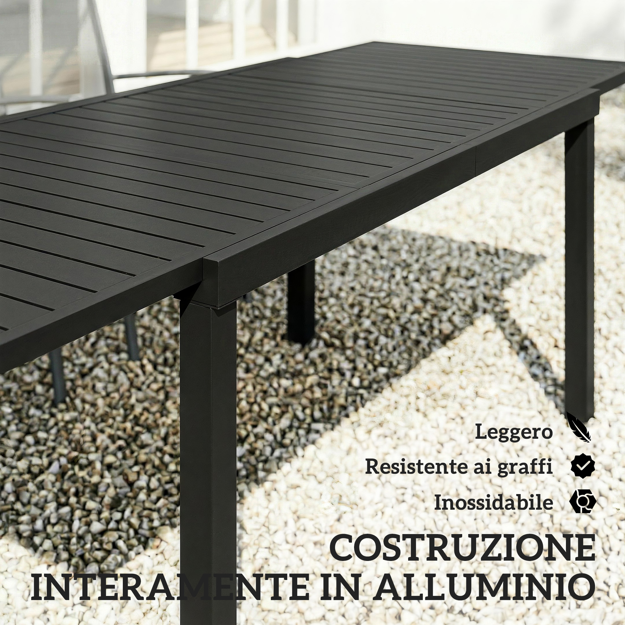Tavolo nero in alluminio con doghe su ghiaia.