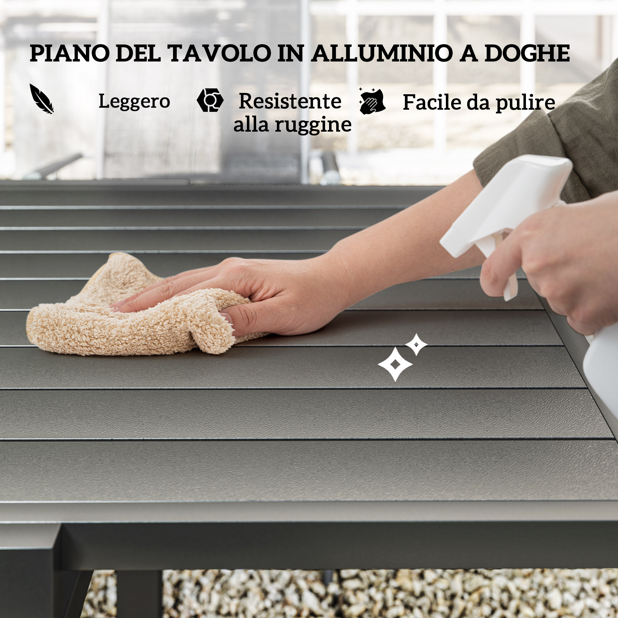 Una mano pulisce una superficie di tavolo con un panno e uno spruzzino.