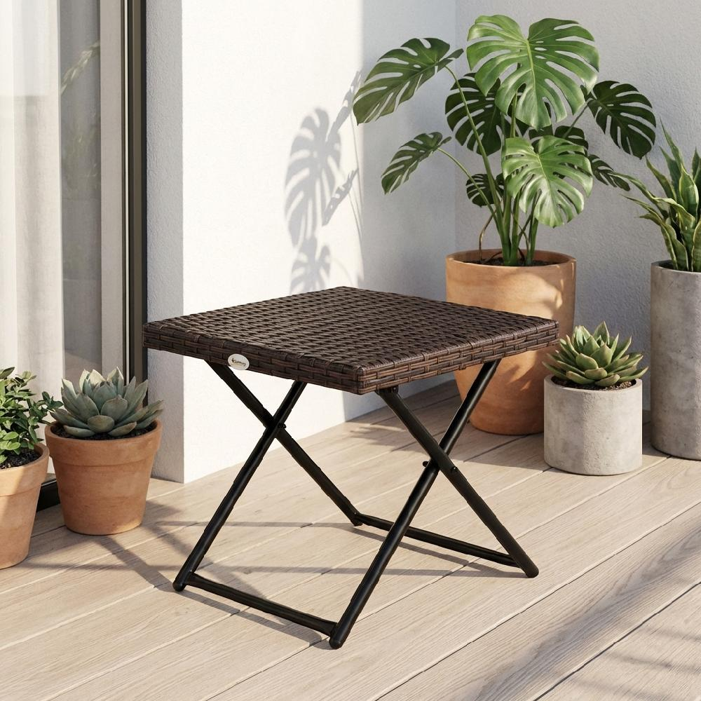 Un tavolo in rattan marrone con telaio in metallo nero si trova su un ponte di legno accanto alle piante.