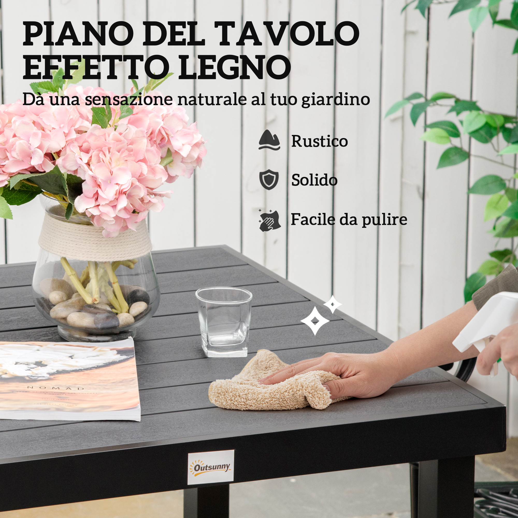Una mano pulisce un tavolo con un panno e spray. Fiori in vaso.