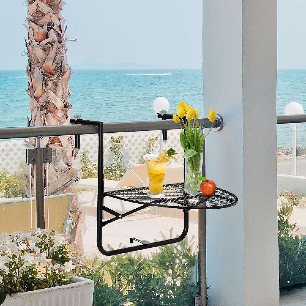 Un tavolino da balcone con bevanda, fiori e mela, con vista sul mare.