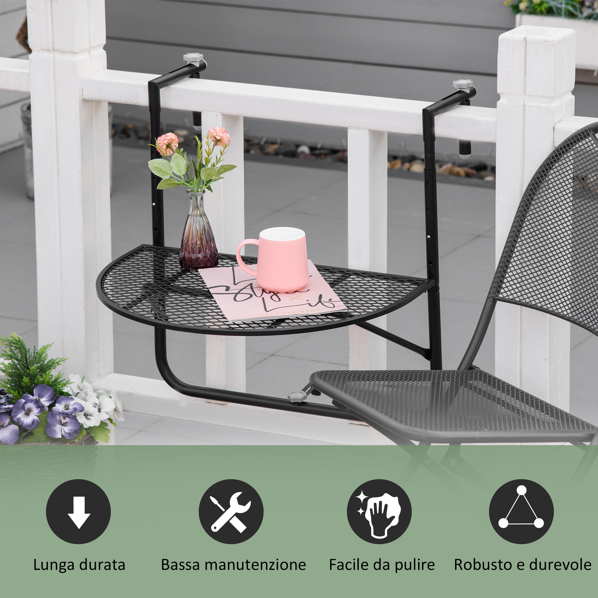 Un tavolino nero da balcone è appeso a una ringhiera bianca. Una tazza rosa è sul tavolo.