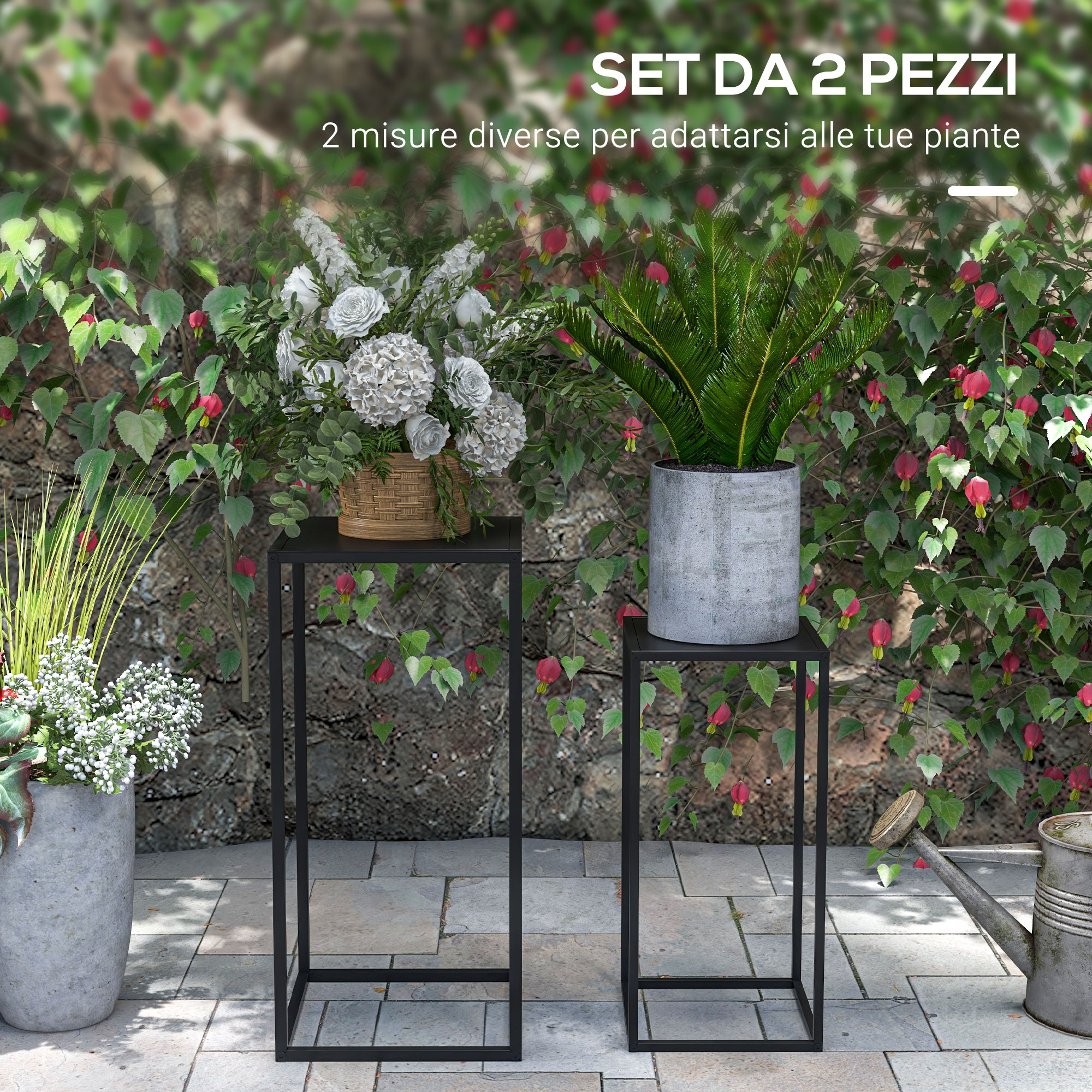 Due supporti neri per piante con piante e fiori davanti a un muro di pietra.