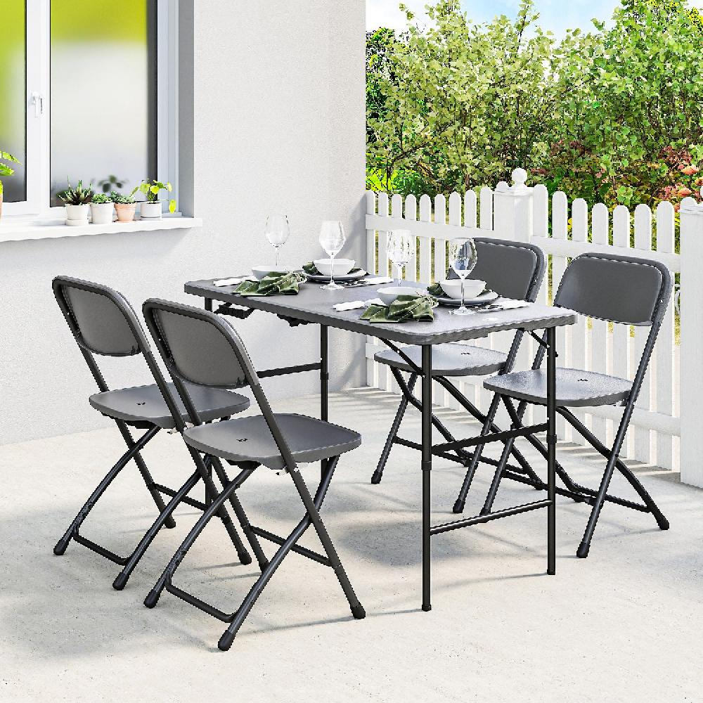 Tavolo pieghevole grigio e quattro sedie su un patio con staccionata bianca e verde.