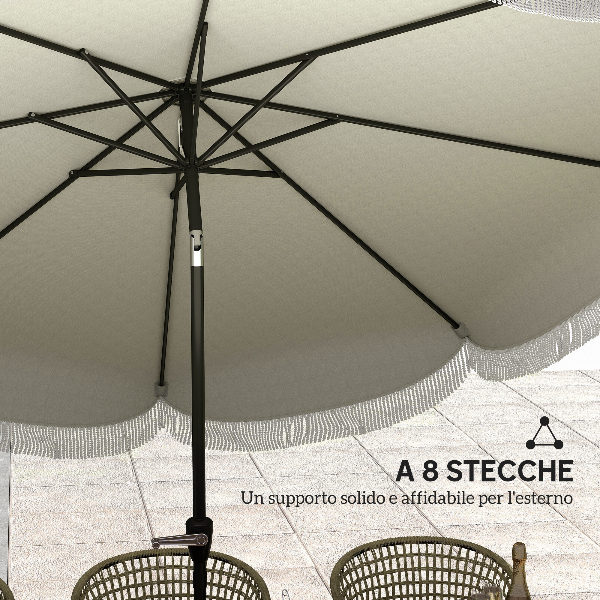 Un ombrellone beige con frange su pavimento piastrellato e sedie in rattan.