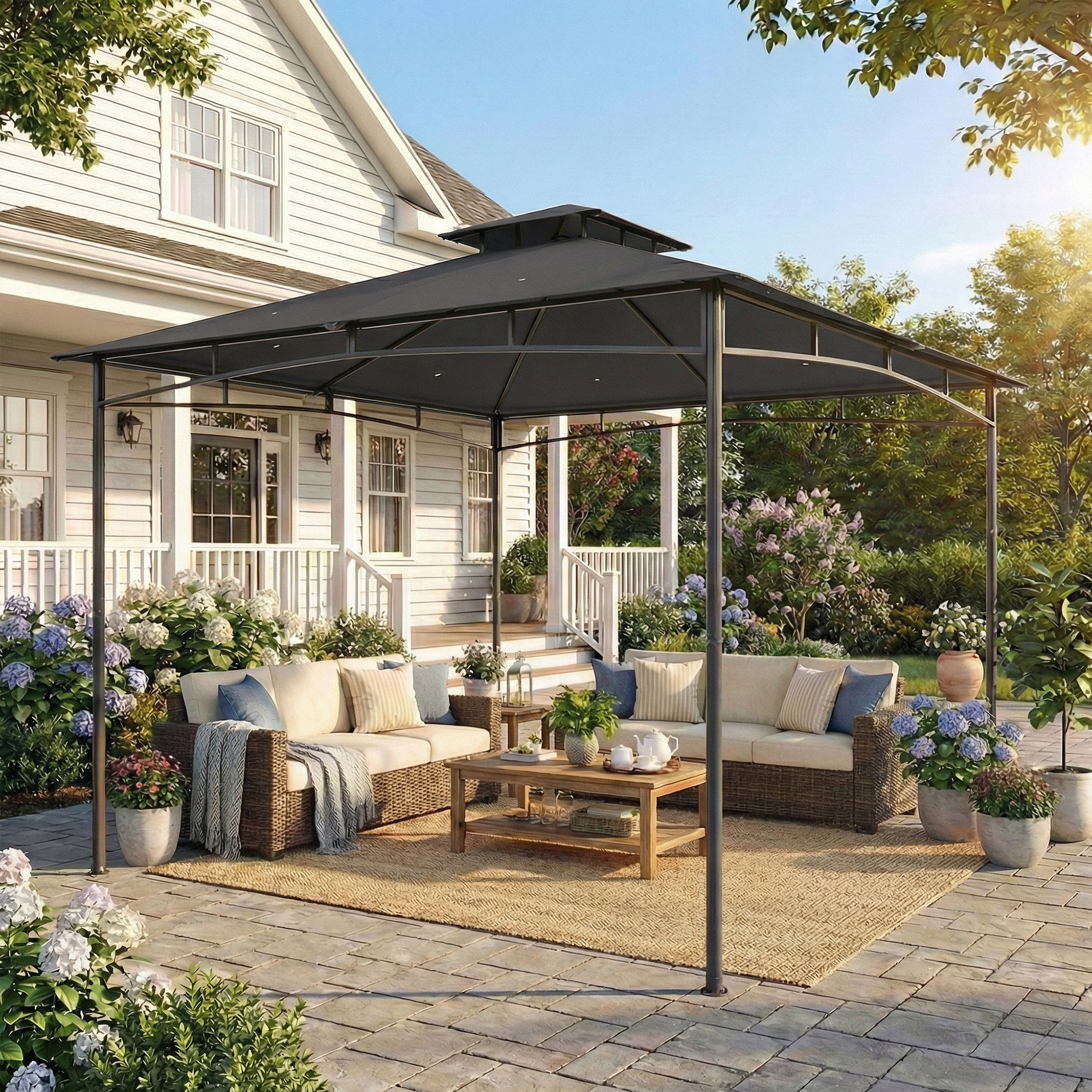 Un gazebo scuro copre un patio con mobili in vimini, tavolino e piante.