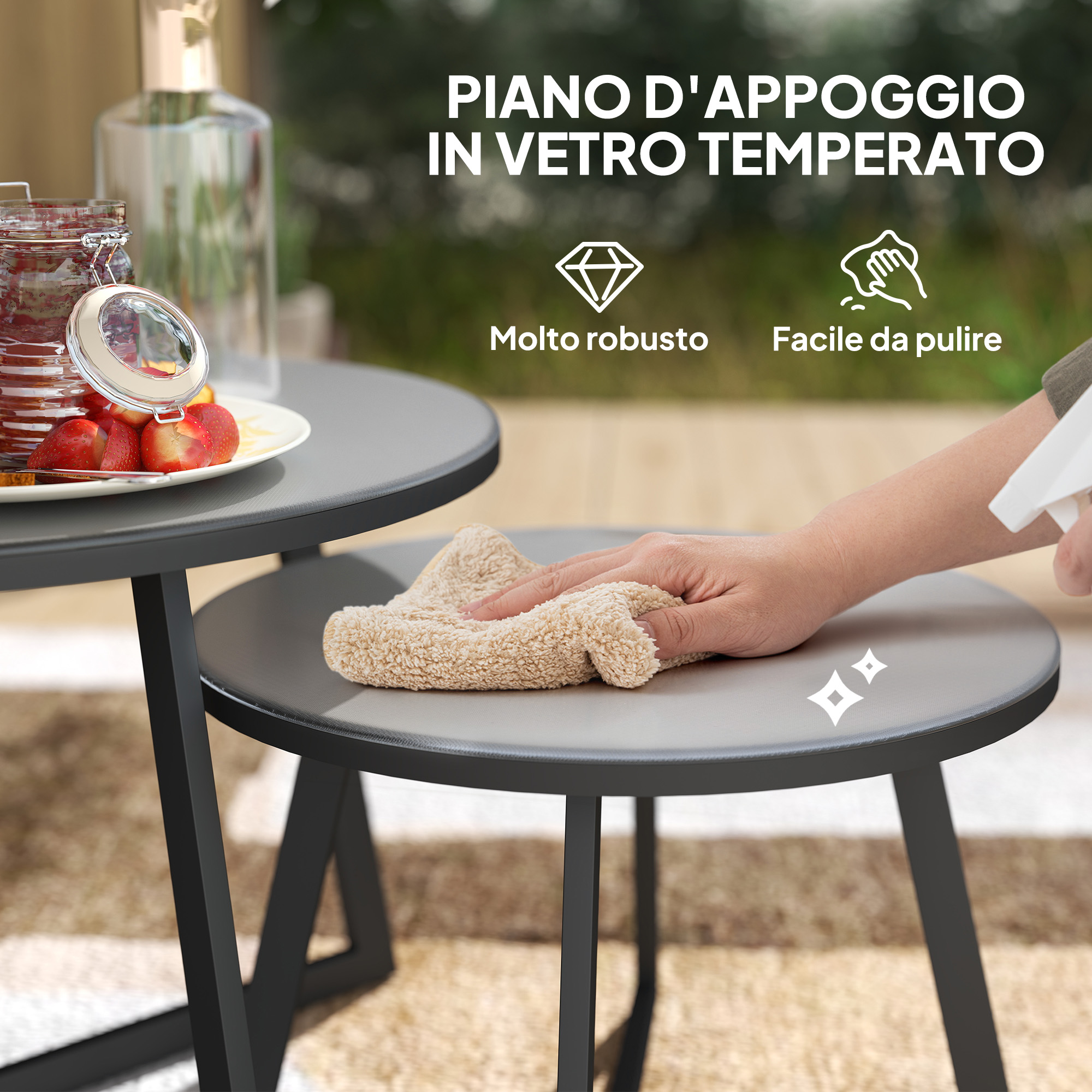 Una mano pulisce un tavolo grigio con un panno beige. Fragole e marmellata sono su un altro tavolo.