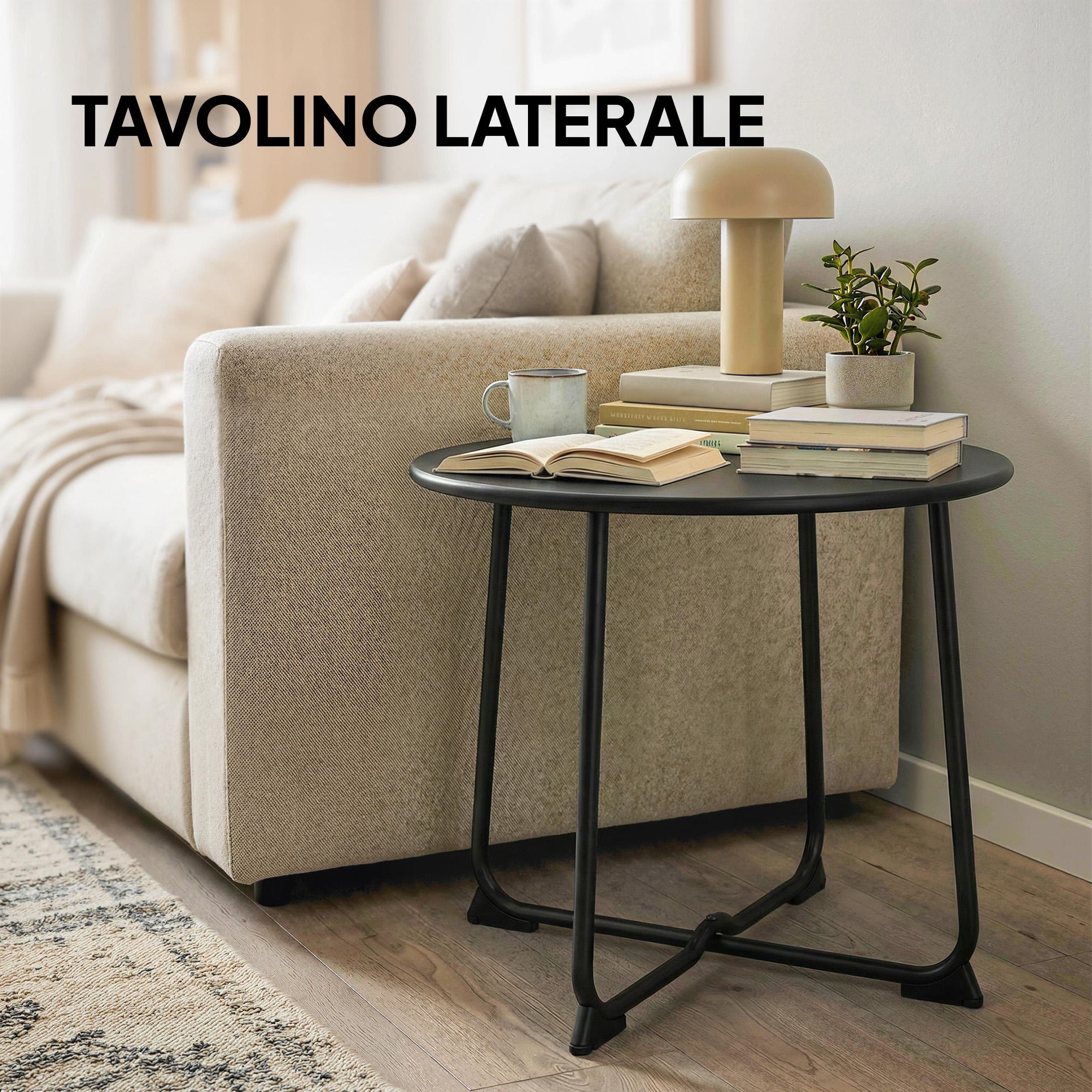 Un tavolino rotondo nero con libri, una lampada e una pianta.