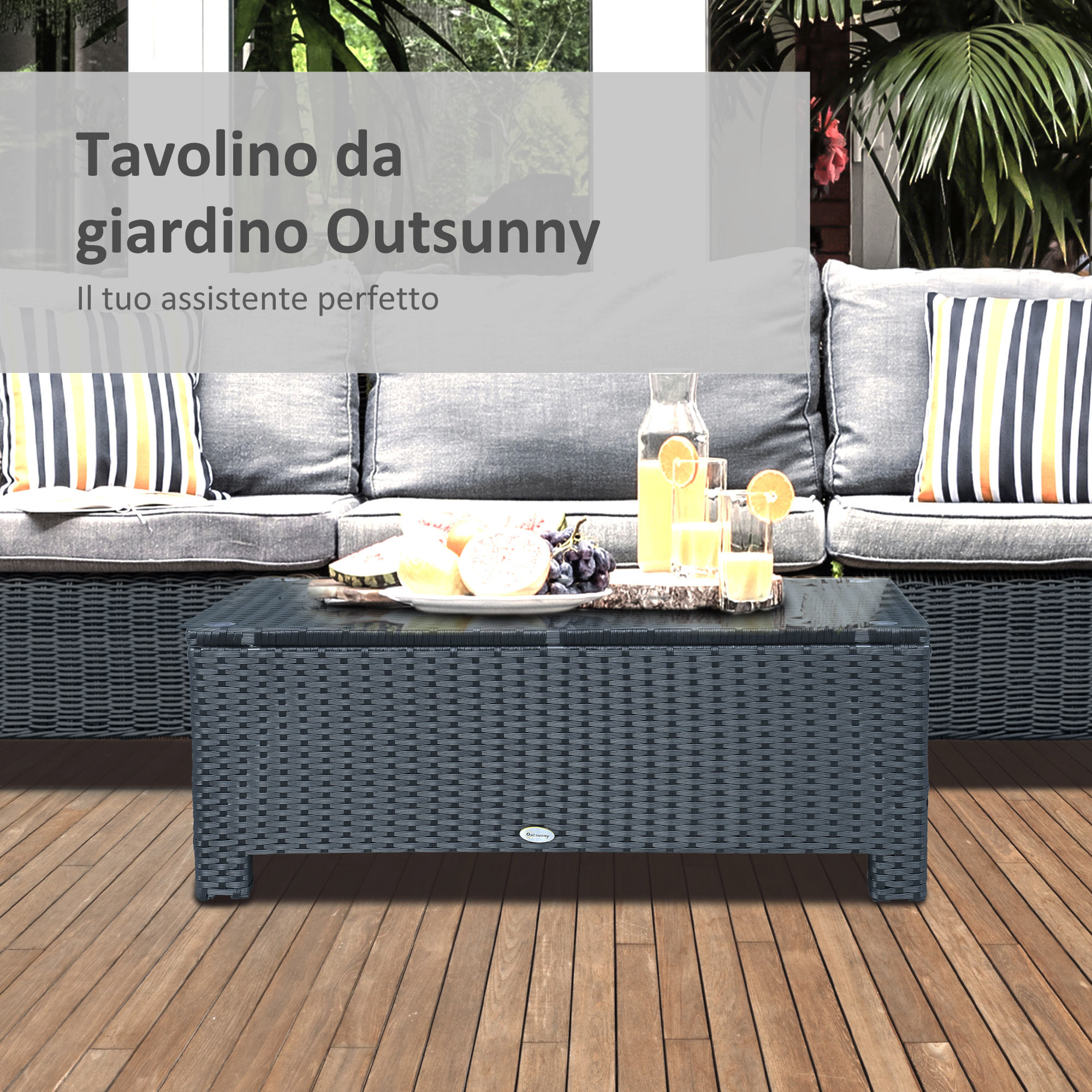 Un tavolo scuro in rattan davanti a un divano con cuscini a strisce, con frutta e succo.