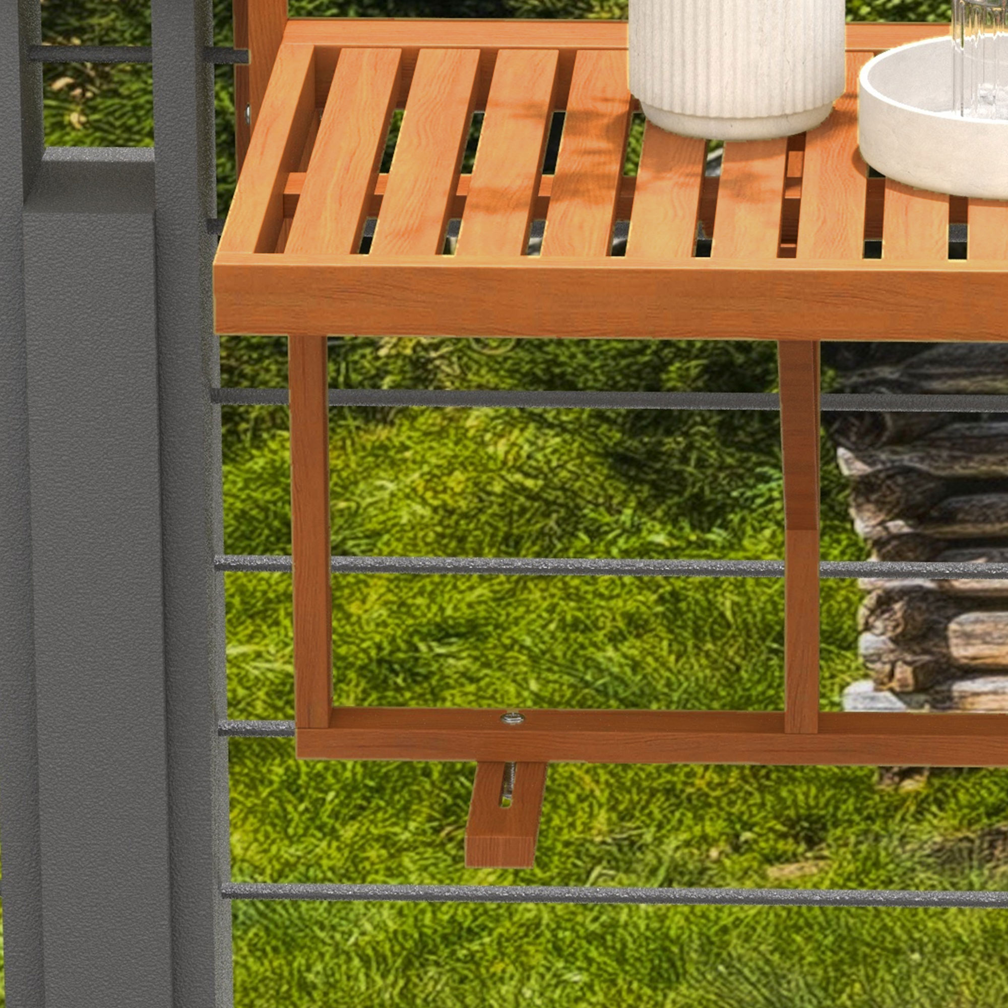 Un tavolo da balcone in legno con vaso e bicchiere su sfondo erboso.