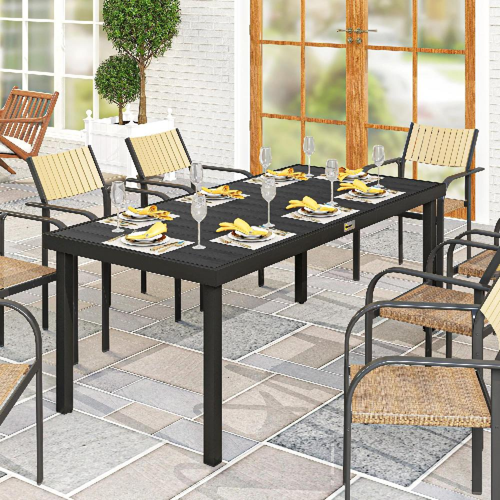 Un tavolo da pranzo nero con otto posti apparecchiati su un patio pavimentato.