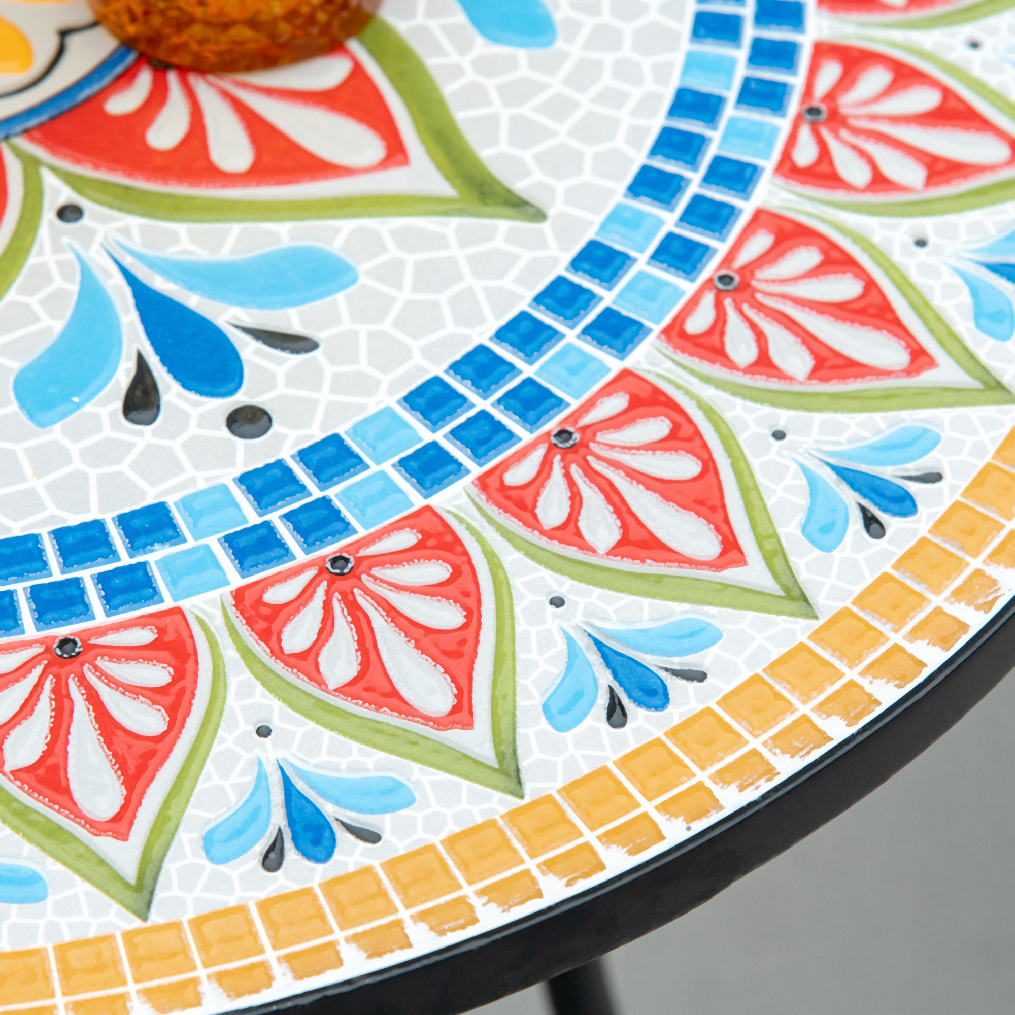 Piano del tavolo a mosaico con fette di frutta colorate e motivi floreali.