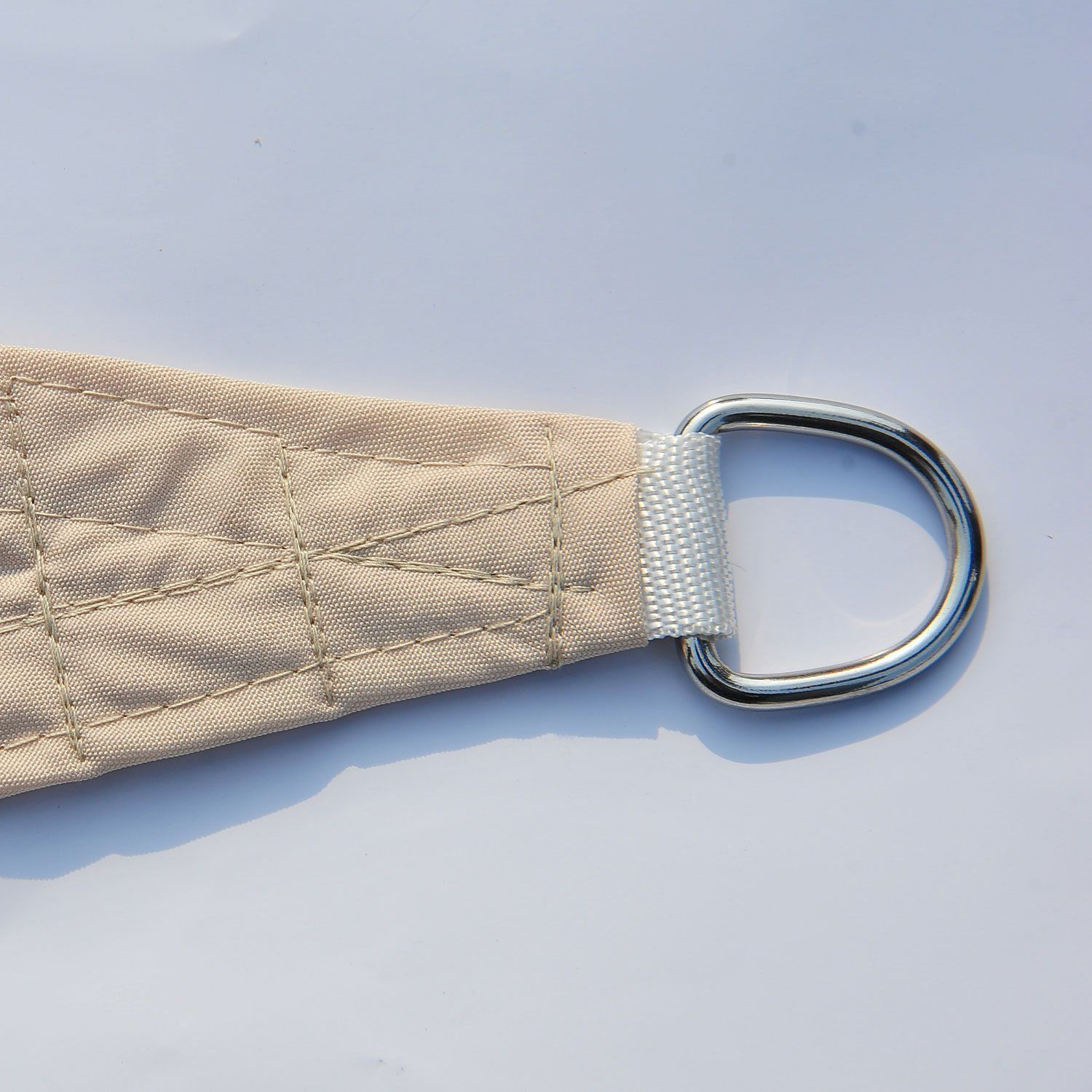 Angolo di vela beige con anello a D metallico, su sfondo bianco.