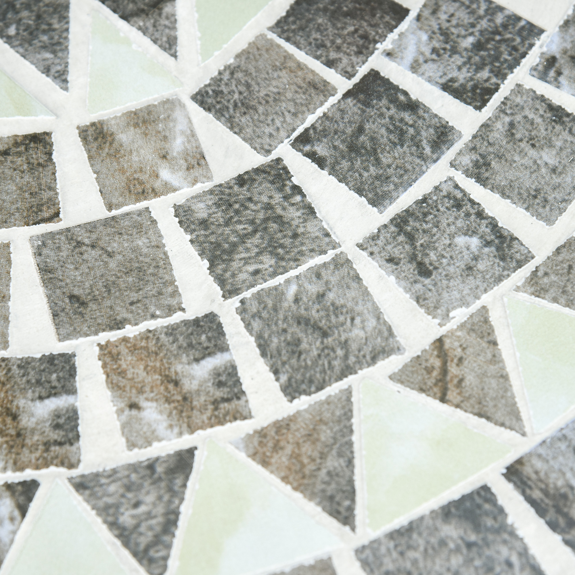 Mosaico di quadrati e triangoli grigi e verde chiaro con stucco bianco.