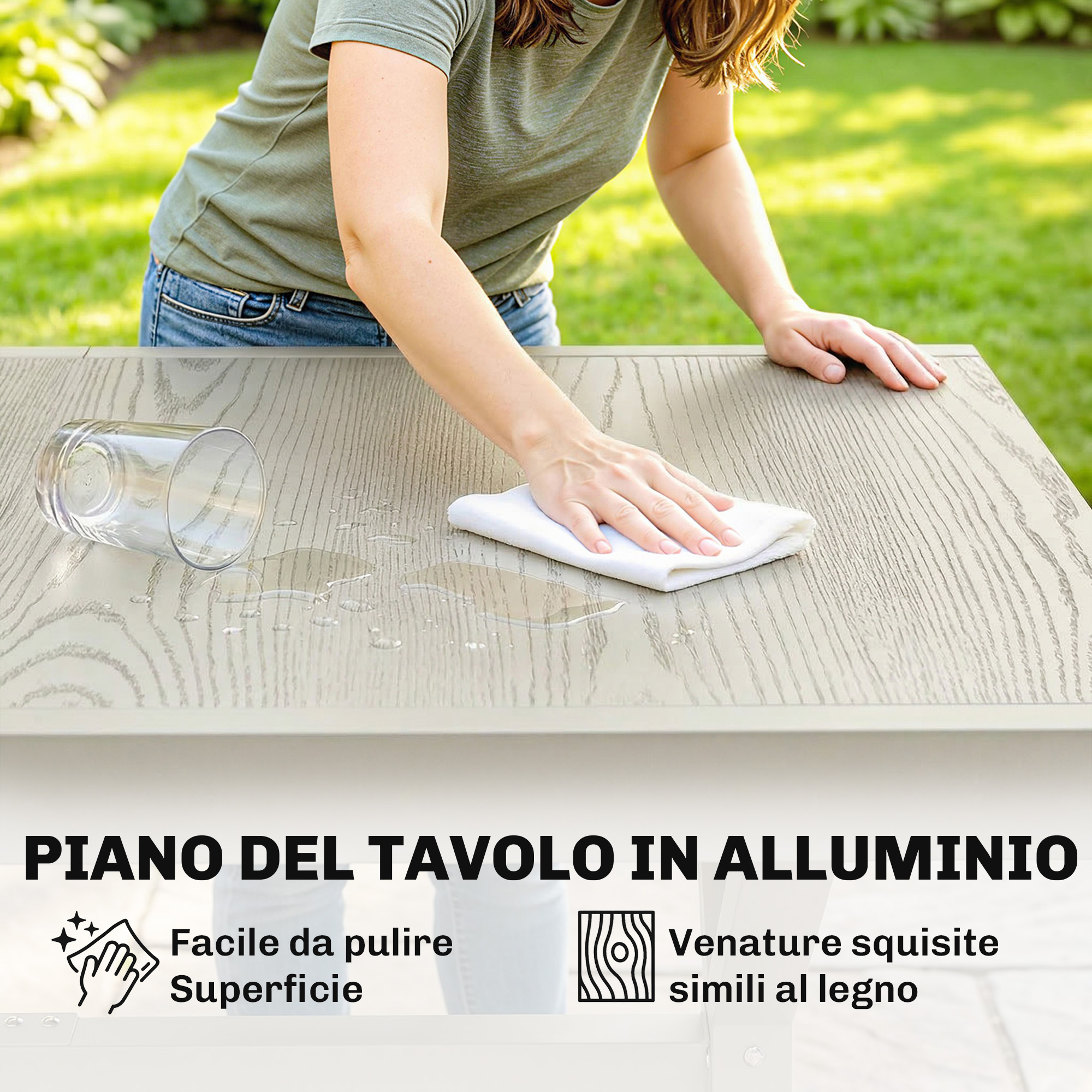 Una donna pulisce un tavolo con un panno. Un bicchiere è rovesciato.