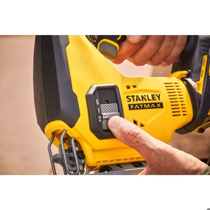 Eine Hand stellt das Geschwindigkeitswählrad an einem gelben Stanley Fatmax Stichsäge-Werkzeug ein.