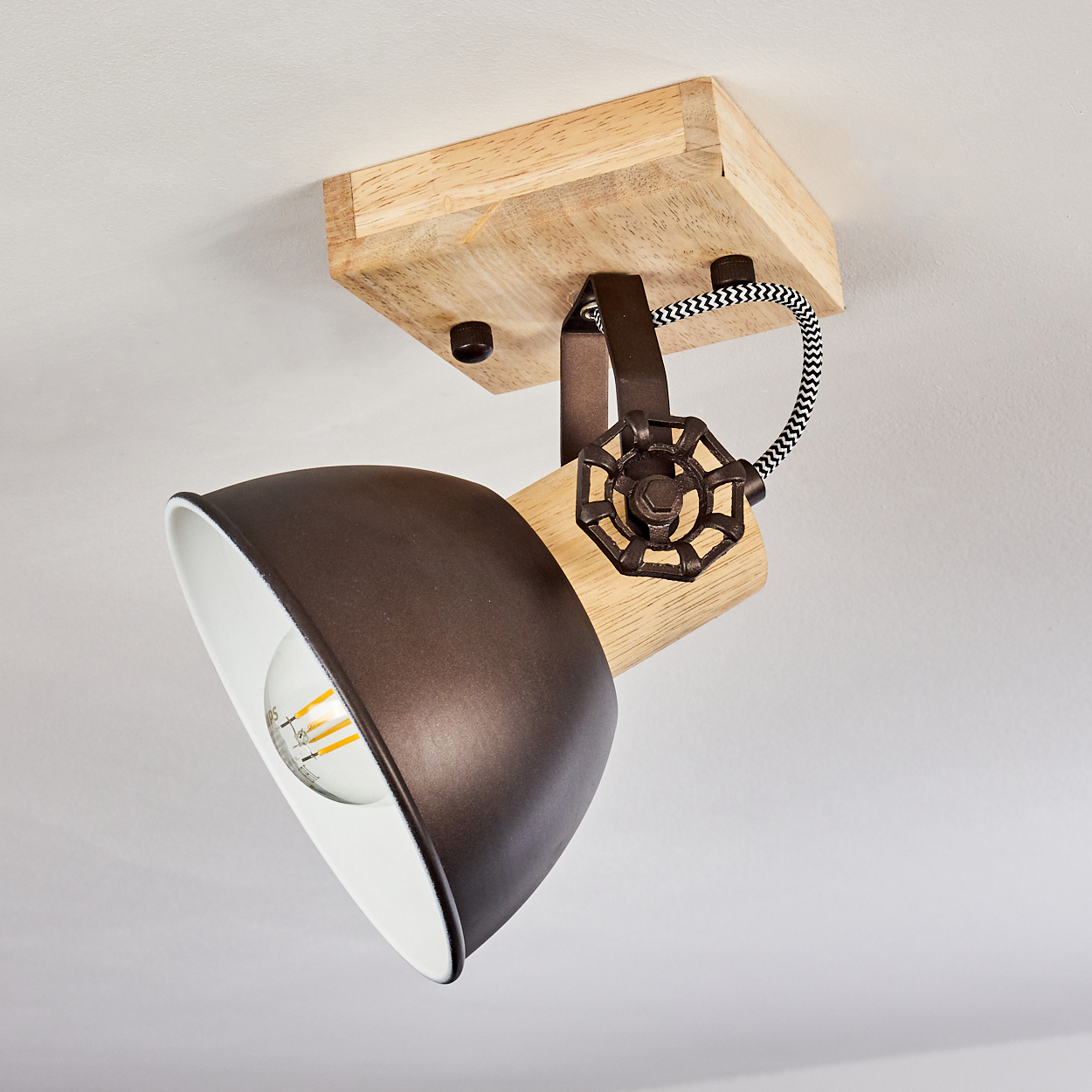 Eine braune Lampe mit Holzelementen, die von der Decke hängt.