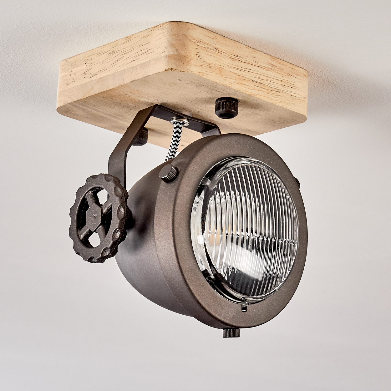 Eine braune Deckenleuchte im Industriestil mit Holzsockel und Rad-Detail.