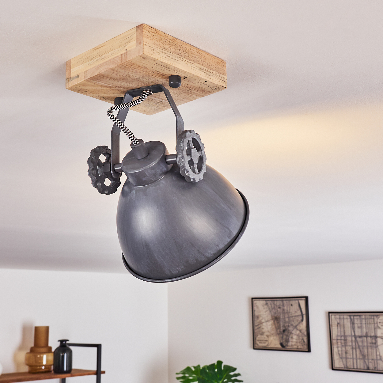 Graue Pendelleuchte mit Holzsockel und Zahnraddetails an der Decke.