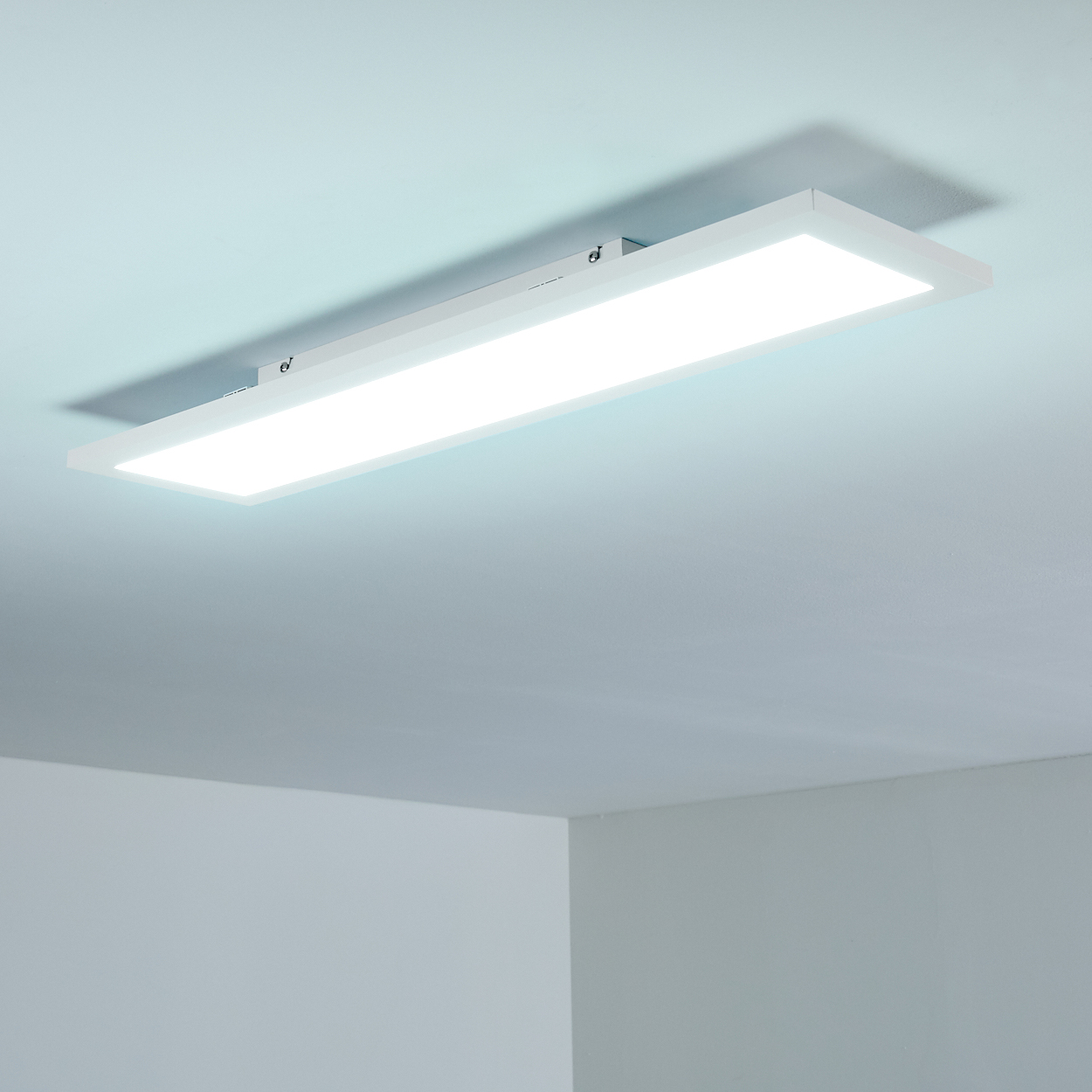 Ein rechteckiger Deckenleuchter mit hellem Licht auf einer blauen Decke.