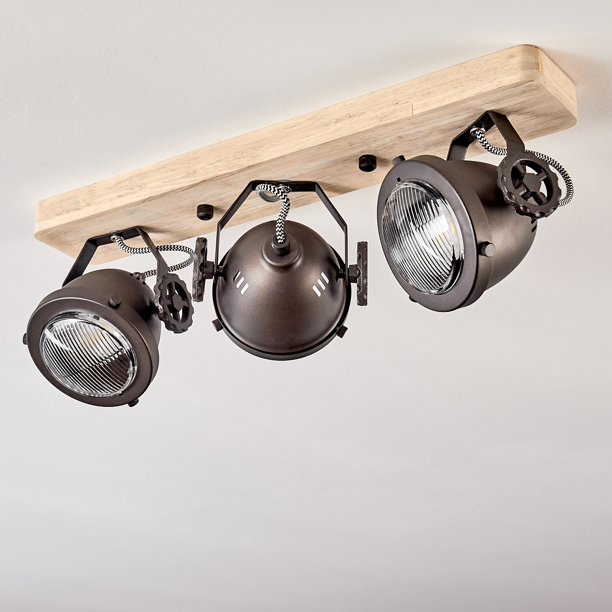Deckenleuchte mit Holzsockel und drei braunen Spots mit verstellbaren Köpfen.