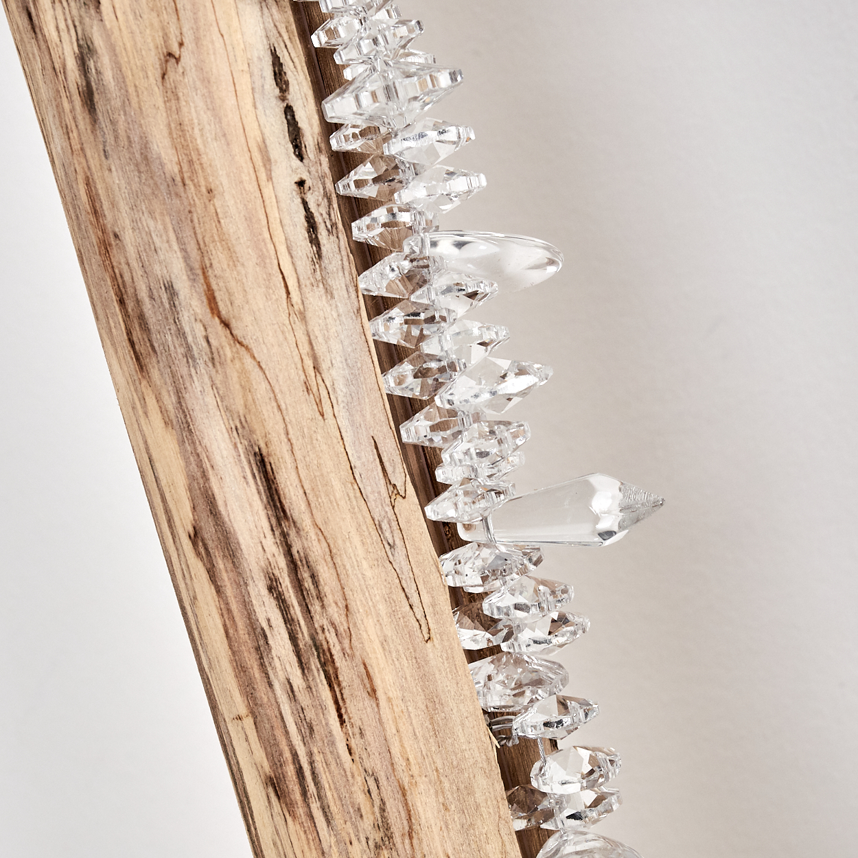 Holzstamm mit einer Reihe von klaren, facettierten Kristallen.