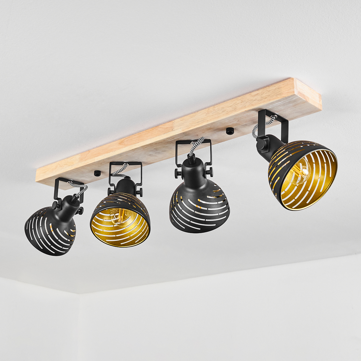Holzdeckenleuchte mit vier schwarzen, schwenkbaren Spots mit goldenen Innenseiten.